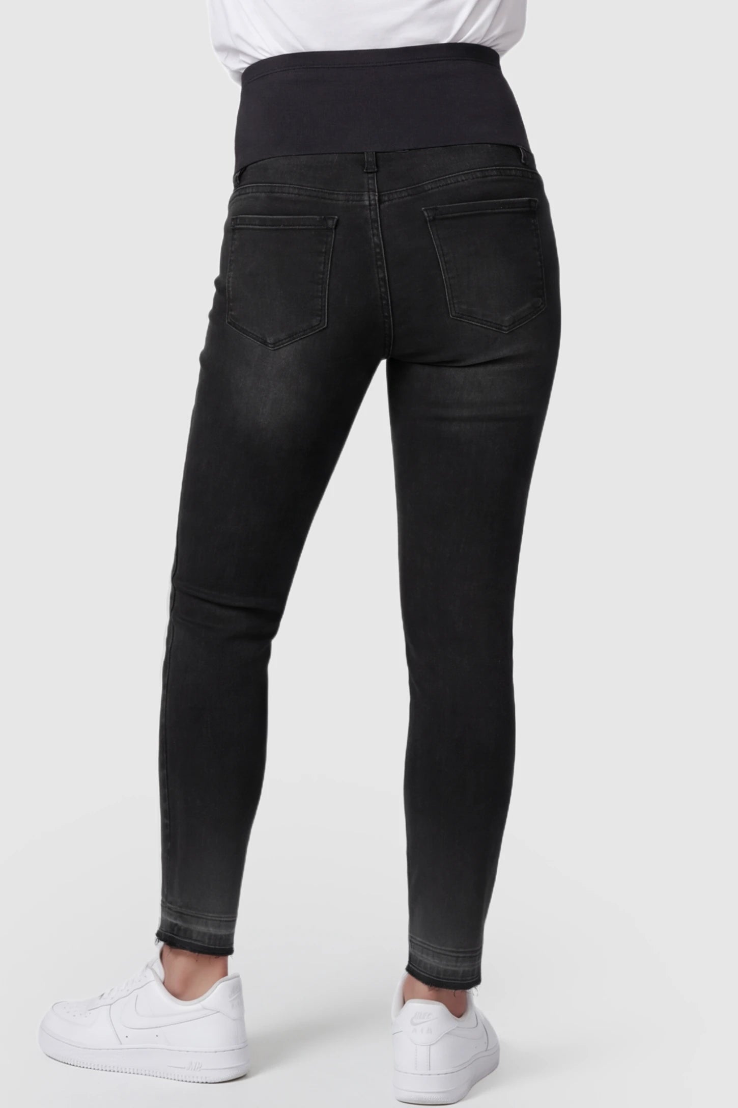 Full Panel Released Hem Maternity Skinny Jeans Full Panel Released Hem Maternity Skinny Jeans in Black featuring a released hem on a pregnant model showing back.