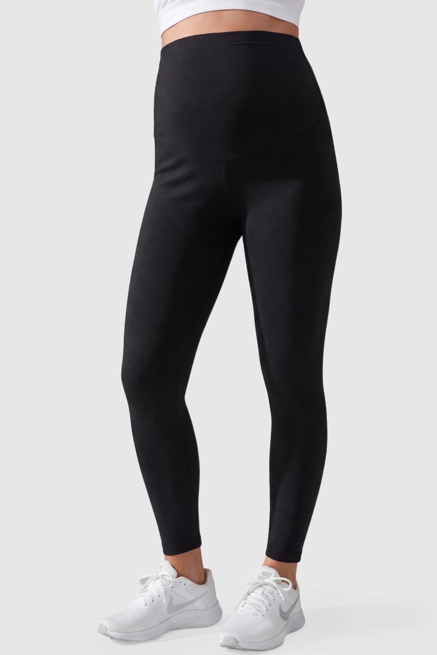 Full Panel Slim Fit Maternity Leggings Full Panel Slim Fit Maternity Leggings in Black featuring a seamless over-the-belly waistband on a pregnant model, front view.