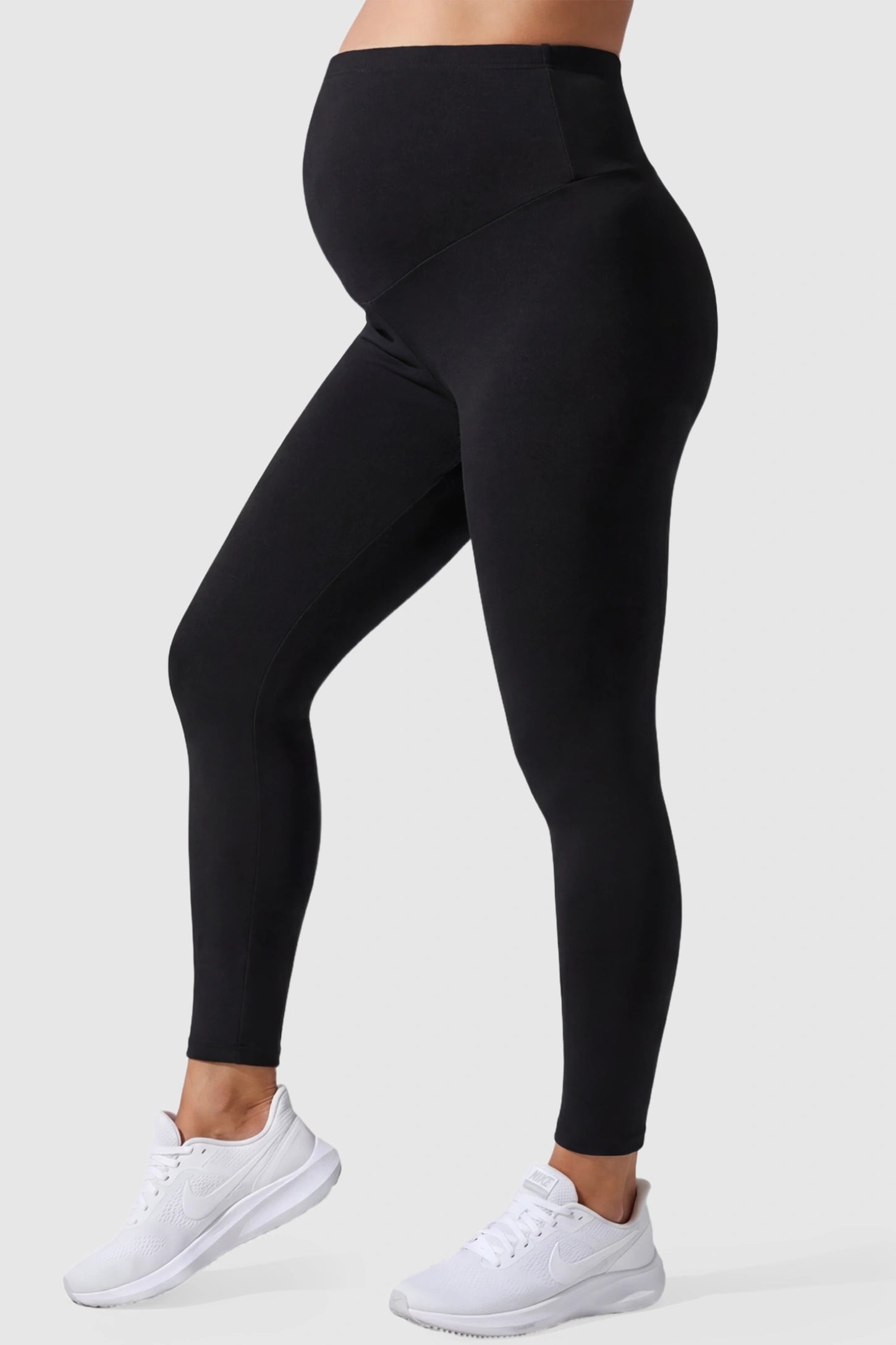 Full Panel Slim Fit Maternity Leggings Full Panel Slim Fit Maternity Leggings in Black featuring a seamless over-the-belly waistband on a pregnant model, side view.