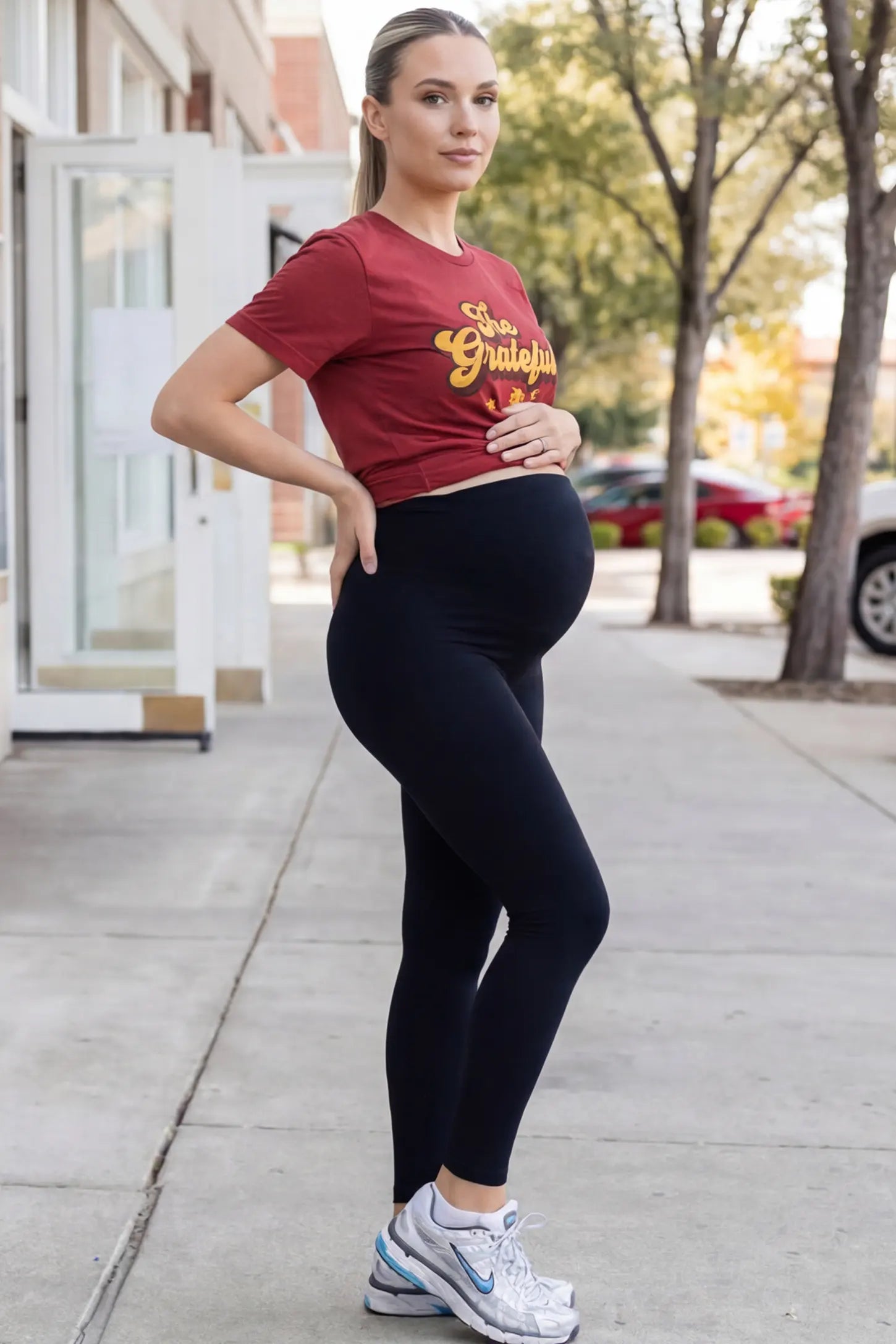 Full Panel Slim Fit Maternity Leggings Full Panel Slim Fit Maternity Leggings in Black featuring a seamless over-the-belly waistband on a pregnant woman in outdoor setting, side view.