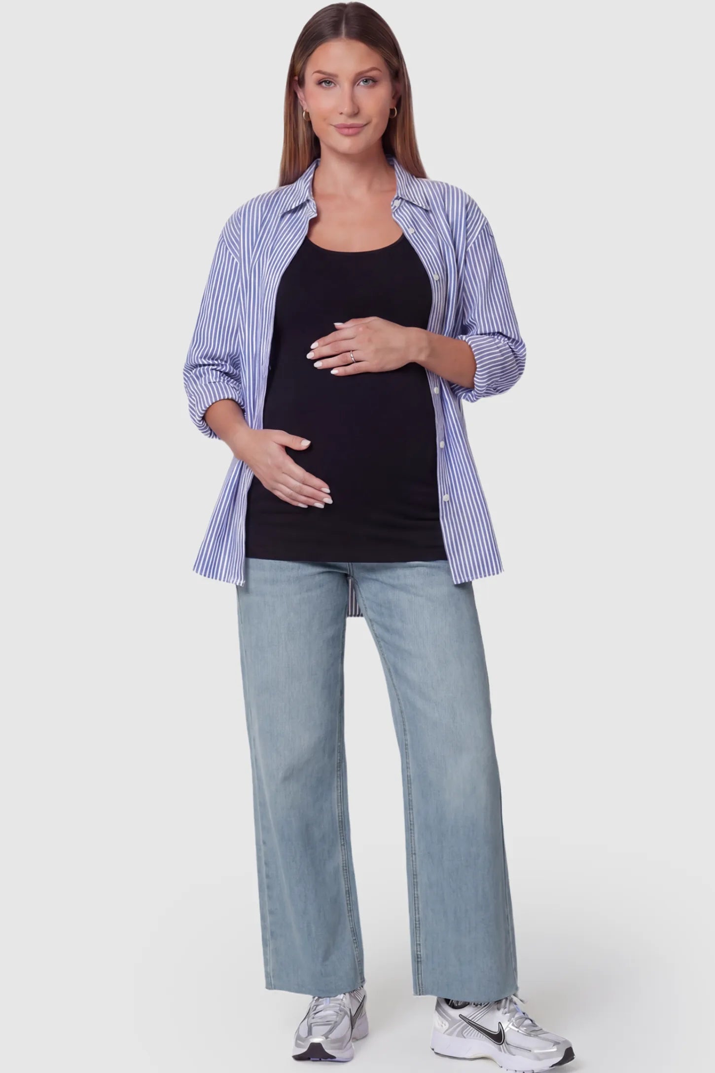 Full Panel Wide Leg Maternity Jeans Full Panel Wide Leg Maternity Jeans in Light Blue featuring a seamless tummy-support band on a pregnant model facing front.