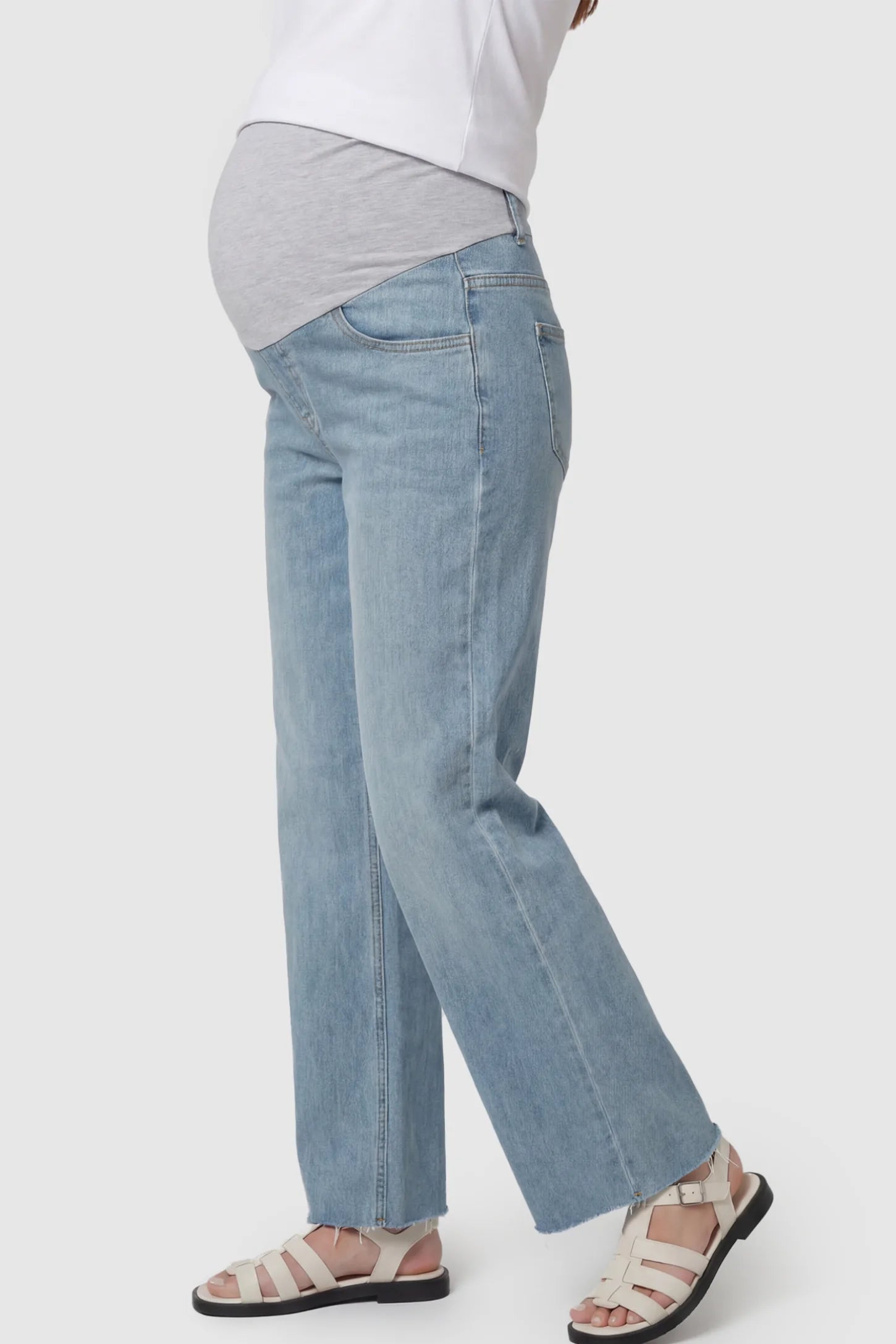 Full Panel Wide Leg Maternity Jeans Full Panel Wide Leg Maternity Jeans in Light Blue featuring a seamless tummy-support band on a pregnant model showing side.