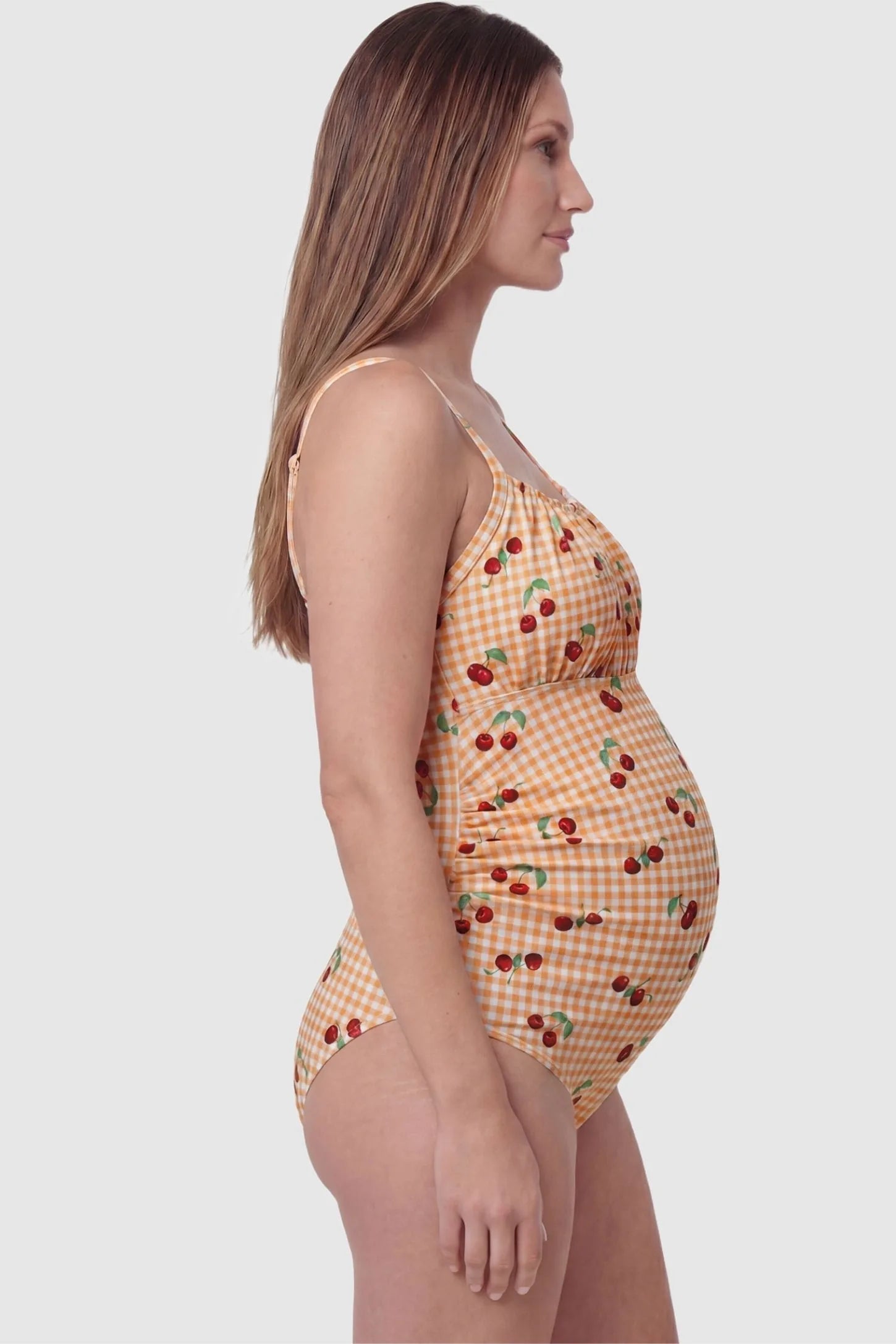 Gingham Matte Ruched Fit Maternity Swimsuit Gingham Matte Ruched Fit Maternity Swimsuit in yellow with side ruching for belly support, side view on pregnant model.