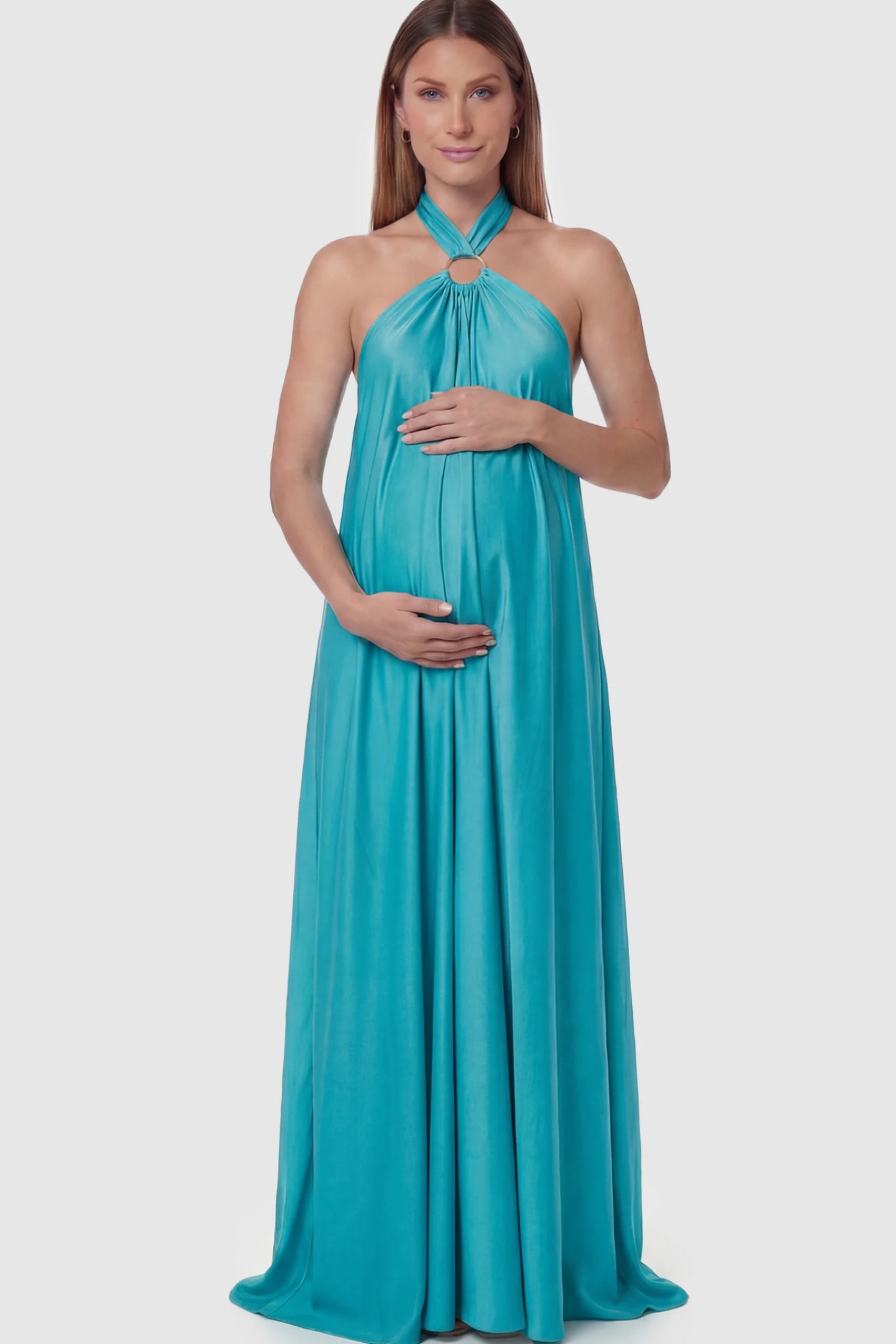 Solid Halter Neck Maternity Maxi Dress Solid Halter Neck Maternity Maxi Dress in Blue featuring a flowing skirt on a pregnant model posing front.