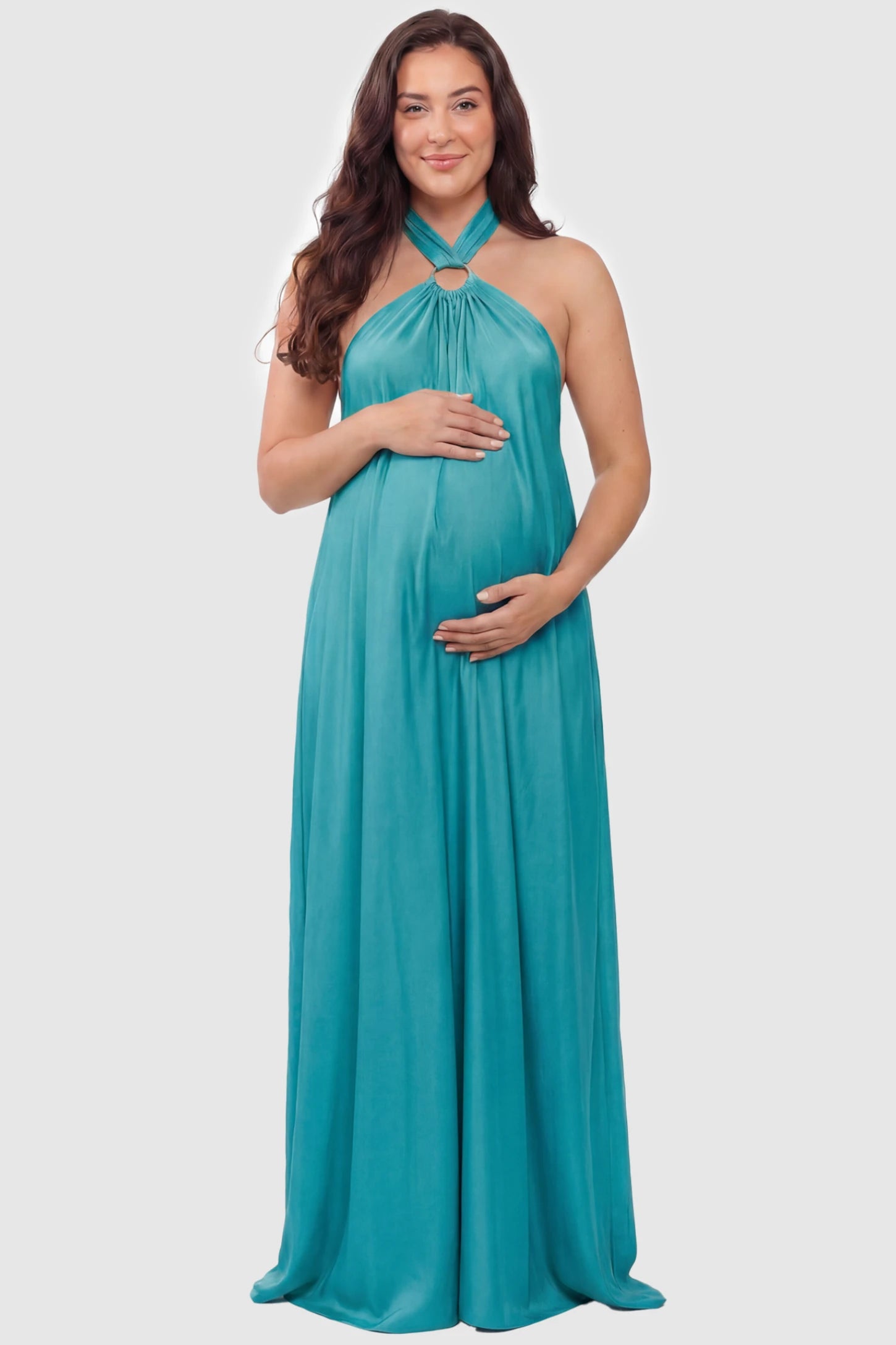 Solid Halter Neck Maternity Maxi Dress Solid Halter Neck Maternity Maxi Dress in Blue featuring a flowing skirt on a plus size pregnant model, front view.