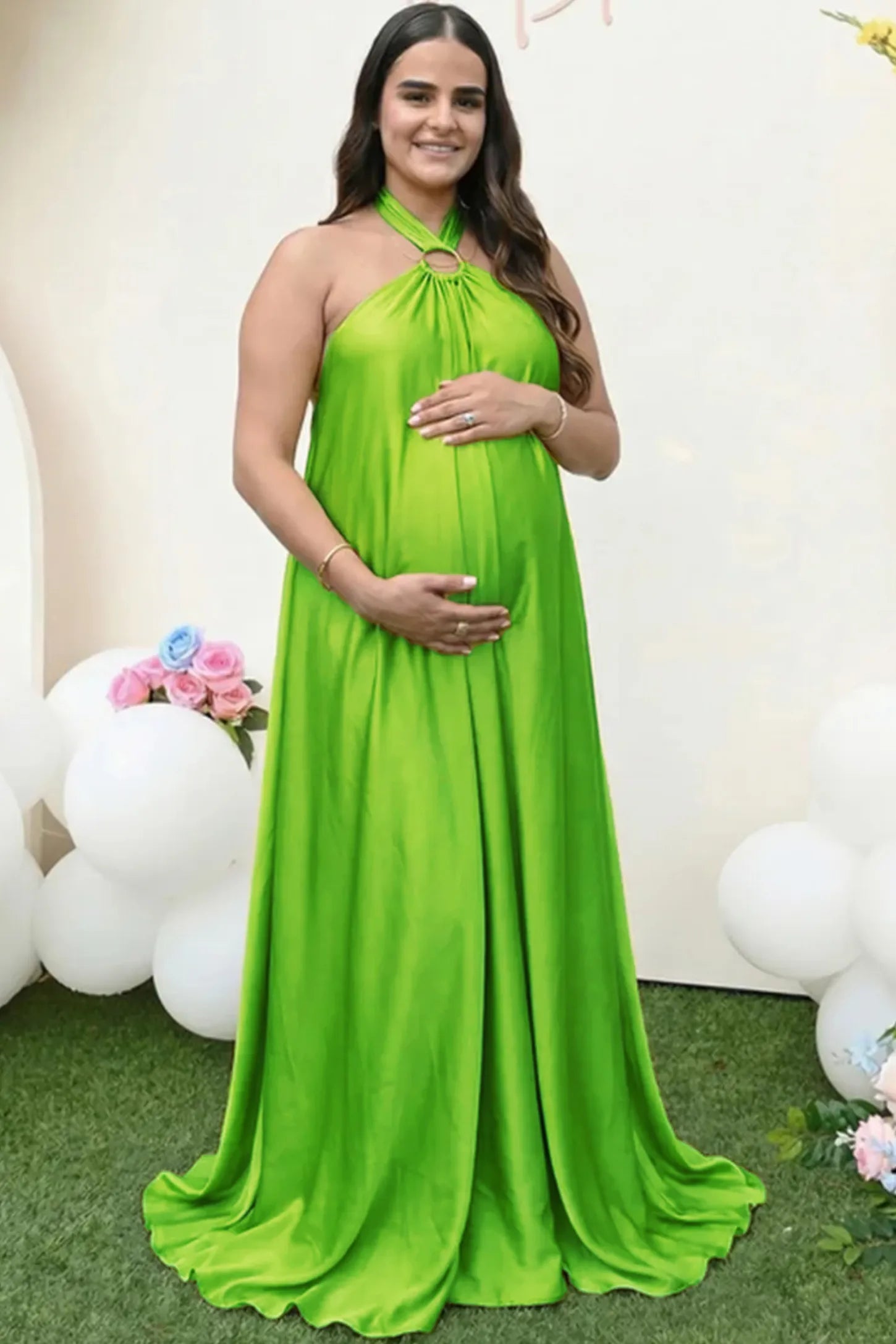 Solid Halter Neck Maternity Maxi Dress Solid Halter Neck Maternity Maxi Dress in Green featuring a flowing skirt on a pregnant woman.