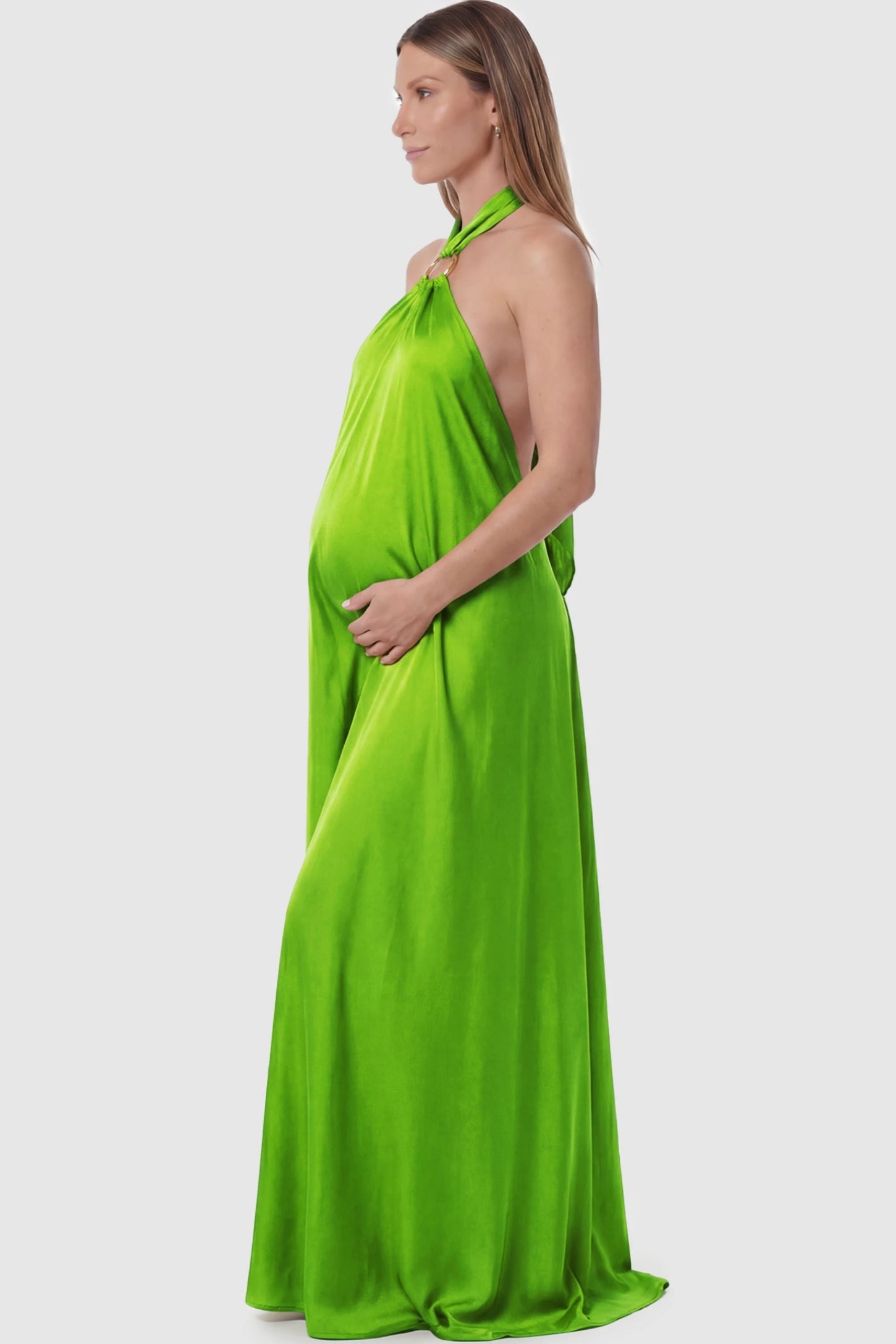 Solid Halter Neck Maternity Maxi Dress Solid Halter Neck Maternity Maxi Dress in Green featuring a flowing skirt and backless design on a pregnant model showing side.