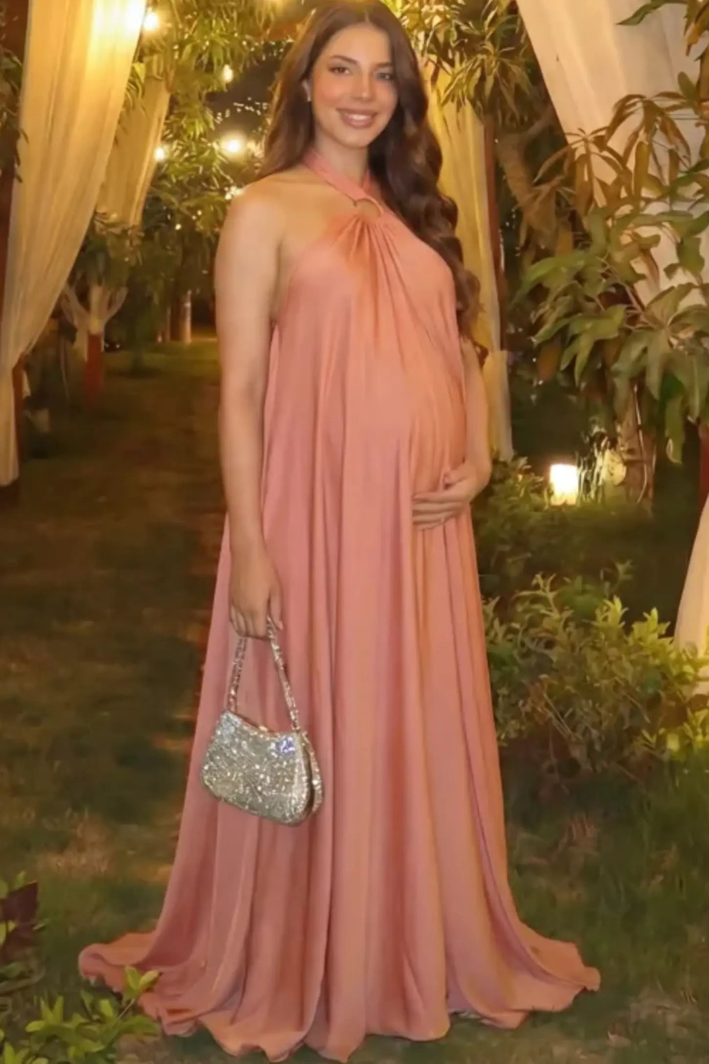 Solid Halter Neck Maternity Maxi Dress Solid Halter Neck Maternity Maxi Dress in Pink featuring a flowing skirt on a pregnant woman.