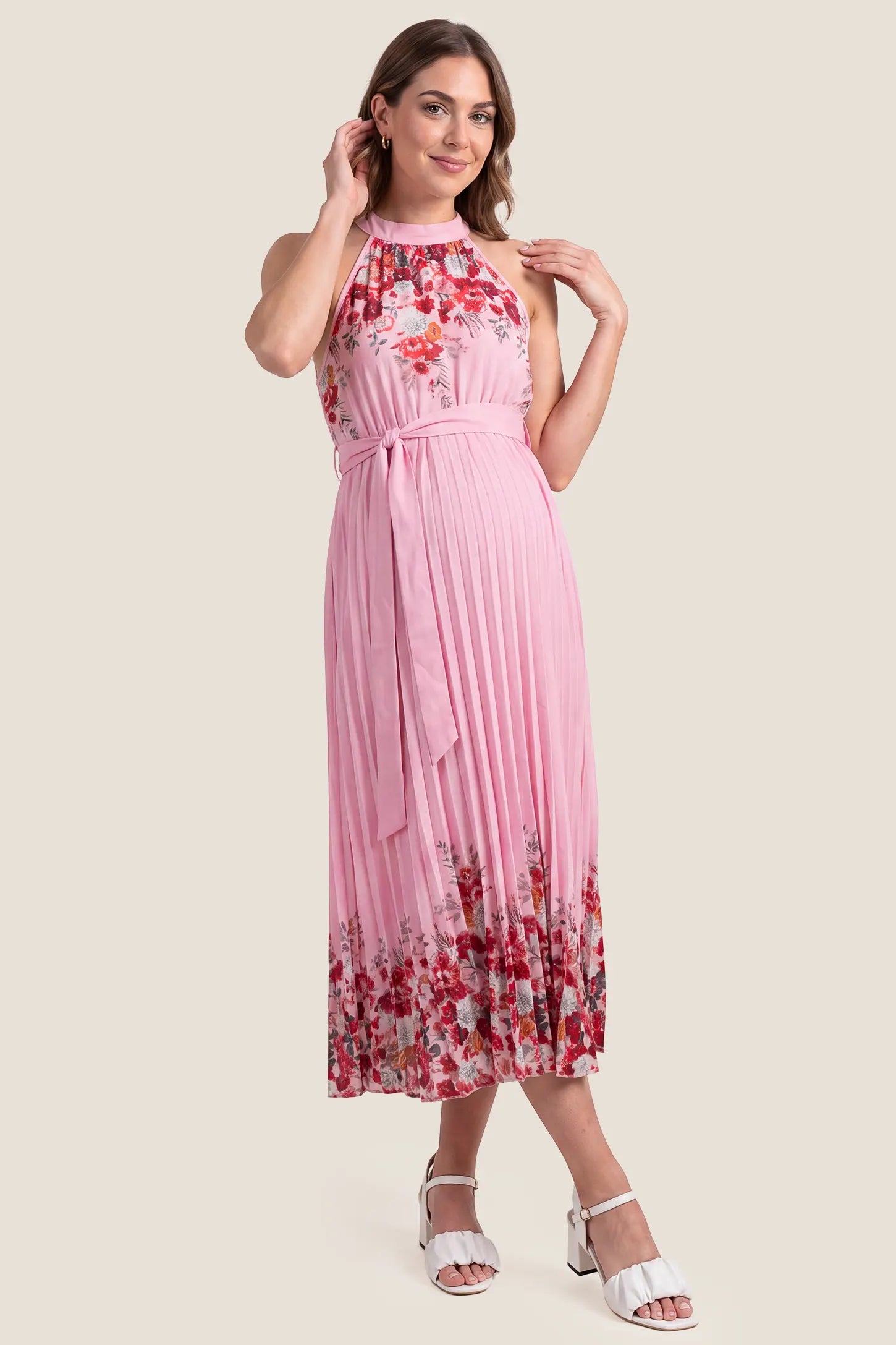 Halter Neck Pleated Maternity Midi Dress Halter Neck Pleated Maternity Midi Dress in Rose Pink Floral on a pregnant model, studio front view.