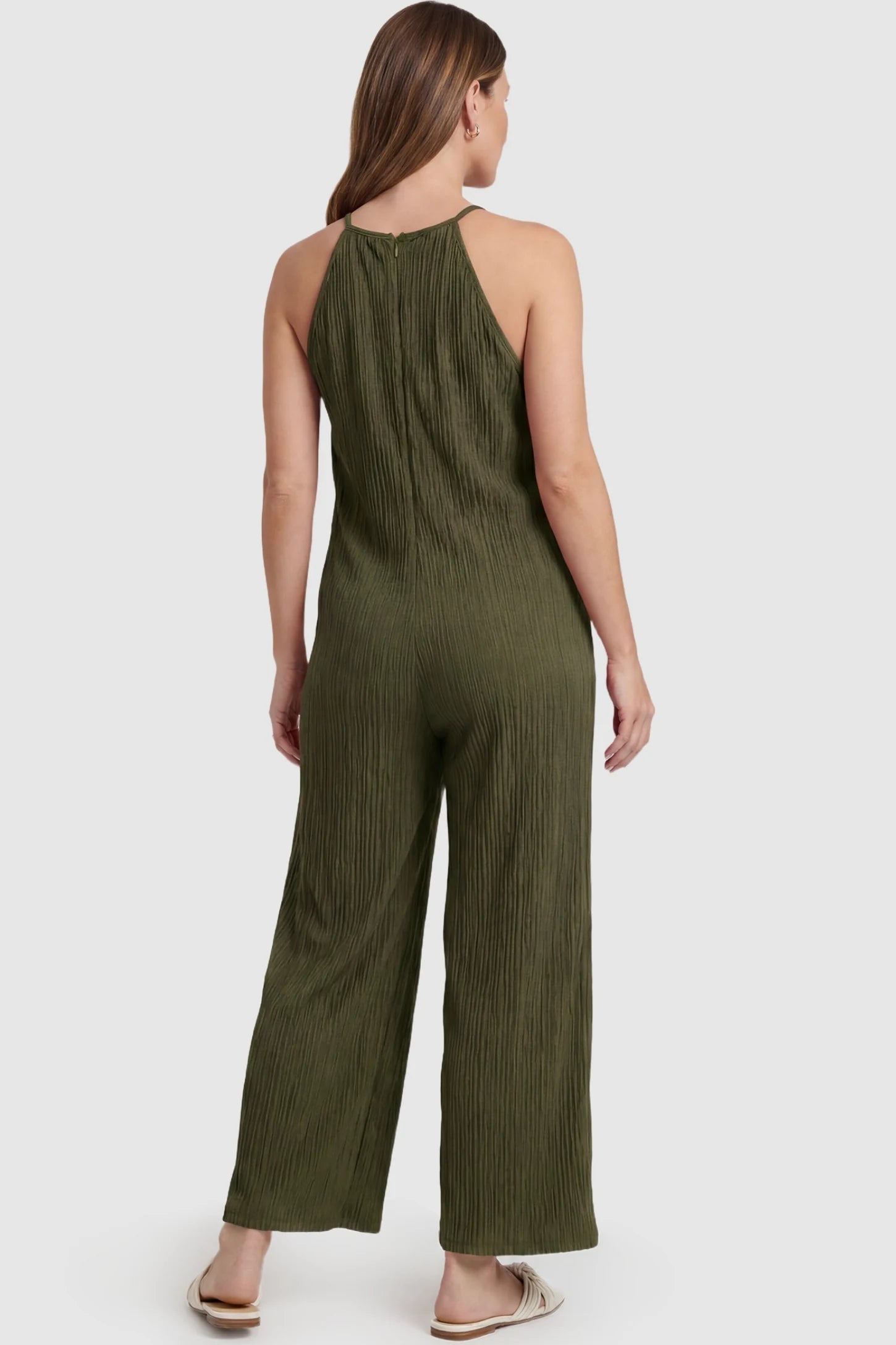 Halter Neck Wide Leg Pocketed Maternity Jumpsuit Halter Neck Wide Leg Pocketed Maternity Jumpsuit in Army Green featuring a halter neck and allover ribbing on a pregnant model, back view.