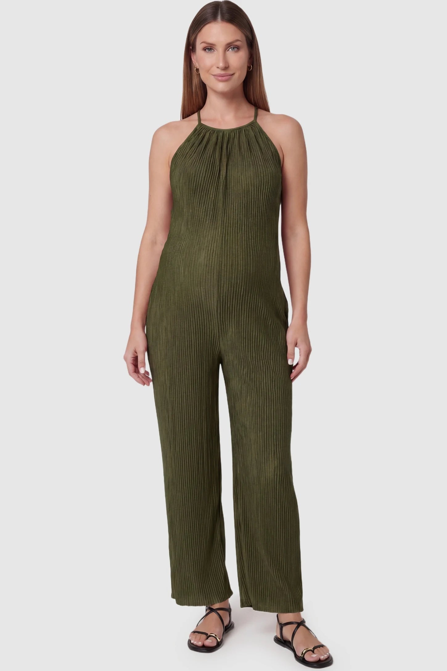 Halter Neck Wide Leg Pocketed Maternity Jumpsuit Halter Neck Wide Leg Pocketed Maternity Jumpsuit in Army Green featuring a gathered halter neck and ribbed texture on a pregnant model, front view.