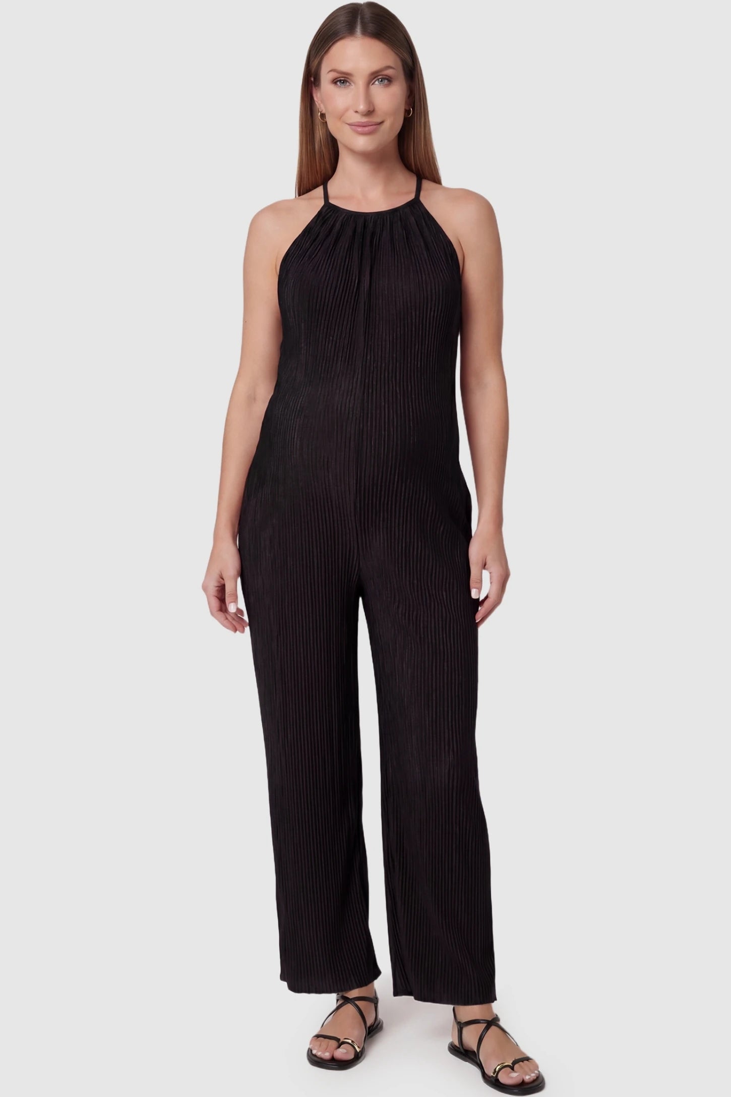 Halter Neck Wide Leg Pocketed Maternity Jumpsuit Halter Neck Wide Leg Pocketed Maternity Jumpsuit in Black featuring a gathered halter neck and ribbed texture on a pregnant model, front view.