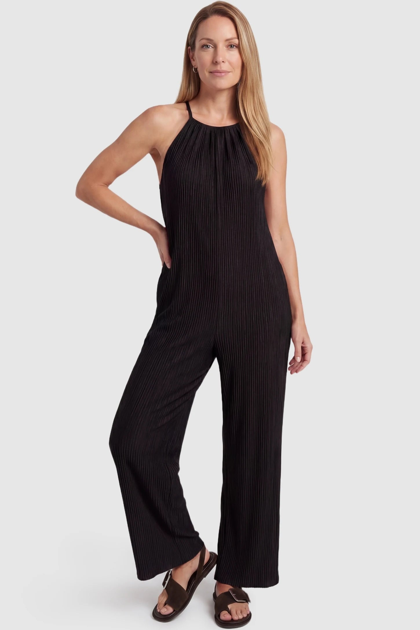 Halter Neck Wide Leg Pocketed Maternity Jumpsuit Halter Neck Wide Leg Pocketed Maternity Jumpsuit in Black featuring a halter neck and soft ribbing on a postpartum model, front view.