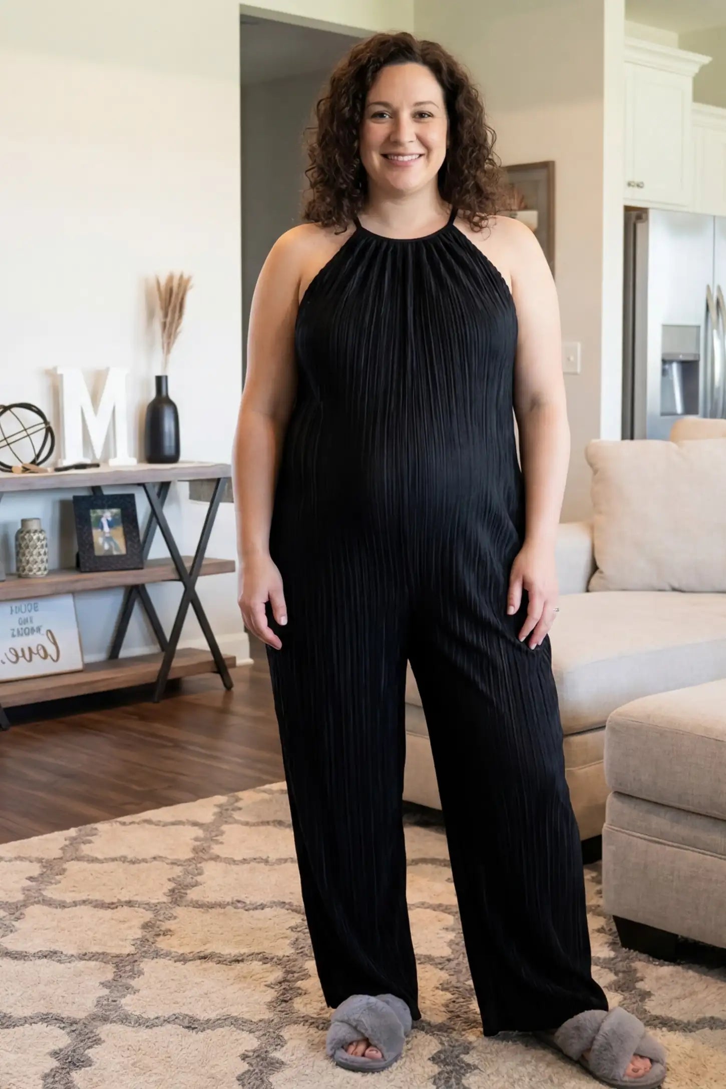 Halter Neck Wide Leg Pocketed Maternity Jumpsuit Halter Neck Wide Leg Pocketed Maternity Jumpsuit in Black featuring a gathered halter neck and ribbed fabric on a pregnant model, UGC-style view.