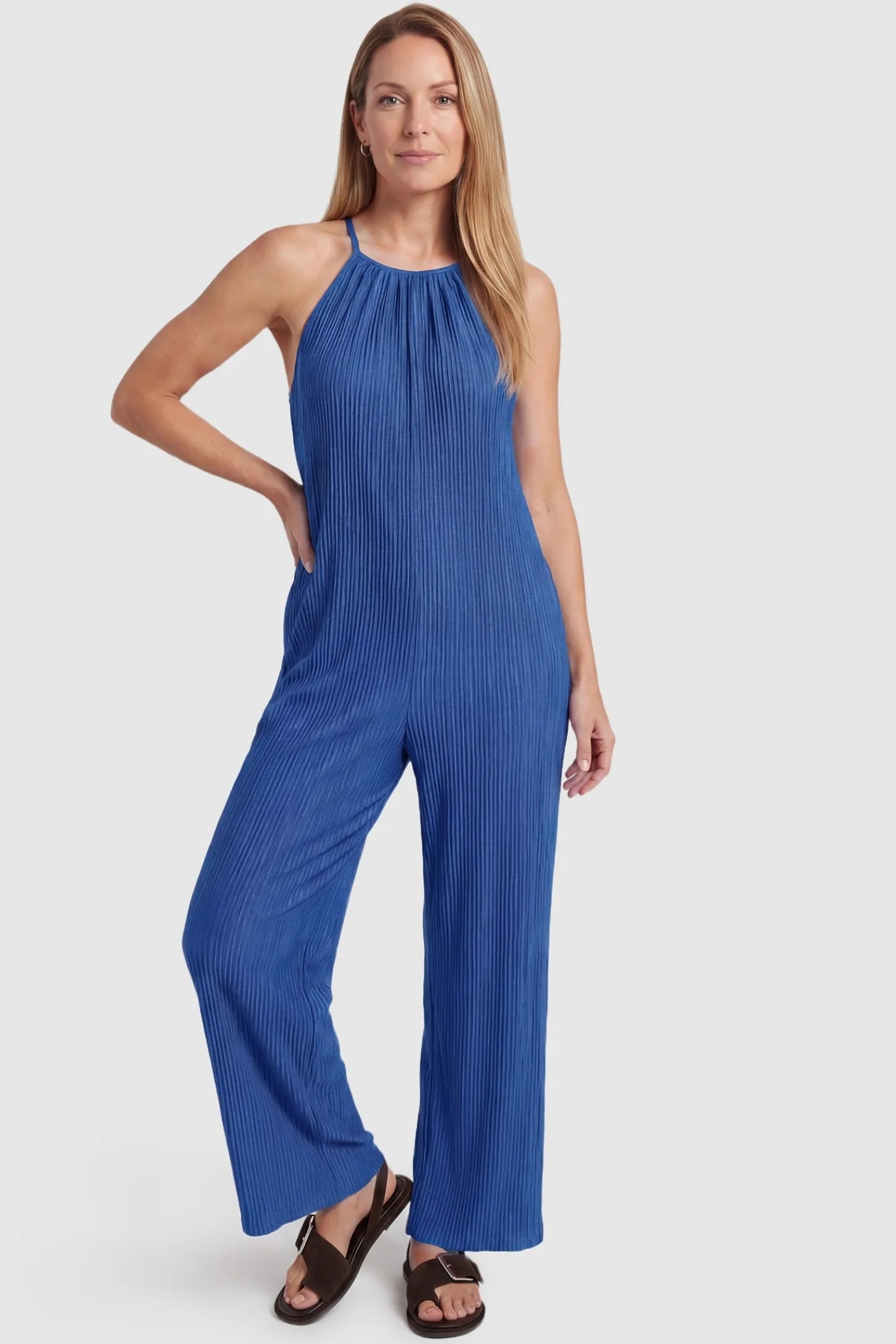 Halter Neck Wide Leg Pocketed Maternity Jumpsuit Halter Neck Wide Leg Pocketed Maternity Jumpsuit in Blue featuring a halter neck and soft ribbing on a postpartum model, front view.