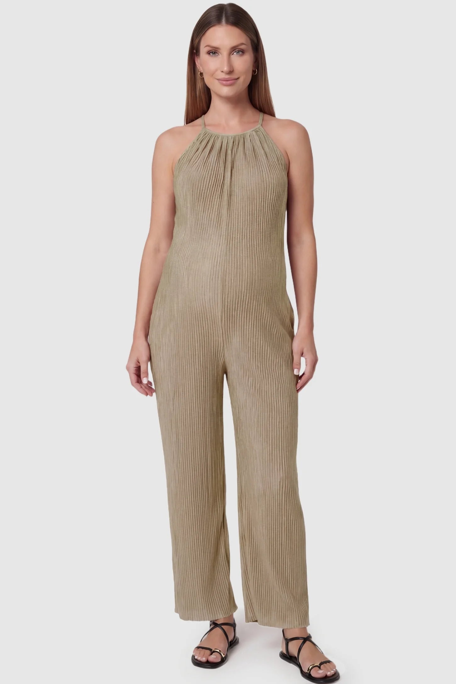 Halter Neck Wide Leg Pocketed Maternity Jumpsuit Halter Neck Wide Leg Pocketed Maternity Jumpsuit in Khaki featuring a gathered halter neck and ribbed texture on a pregnant model, front view.