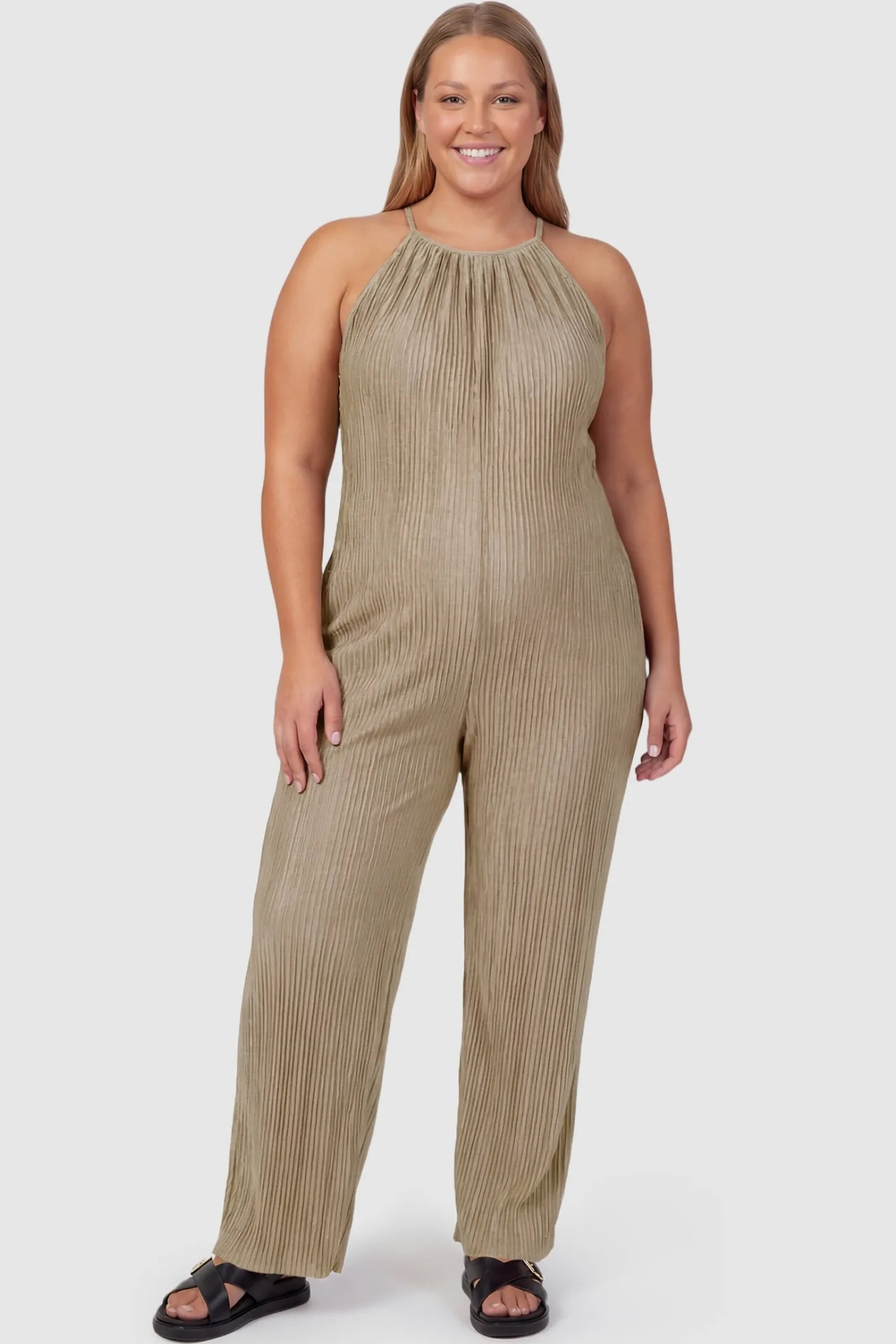 Halter Neck Wide Leg Pocketed Maternity Jumpsuit Halter Neck Wide Leg Pocketed Maternity Jumpsuit in Khaki featuring a gathered halter neck and ribbed texture on a plus-size pregnant model, front view.