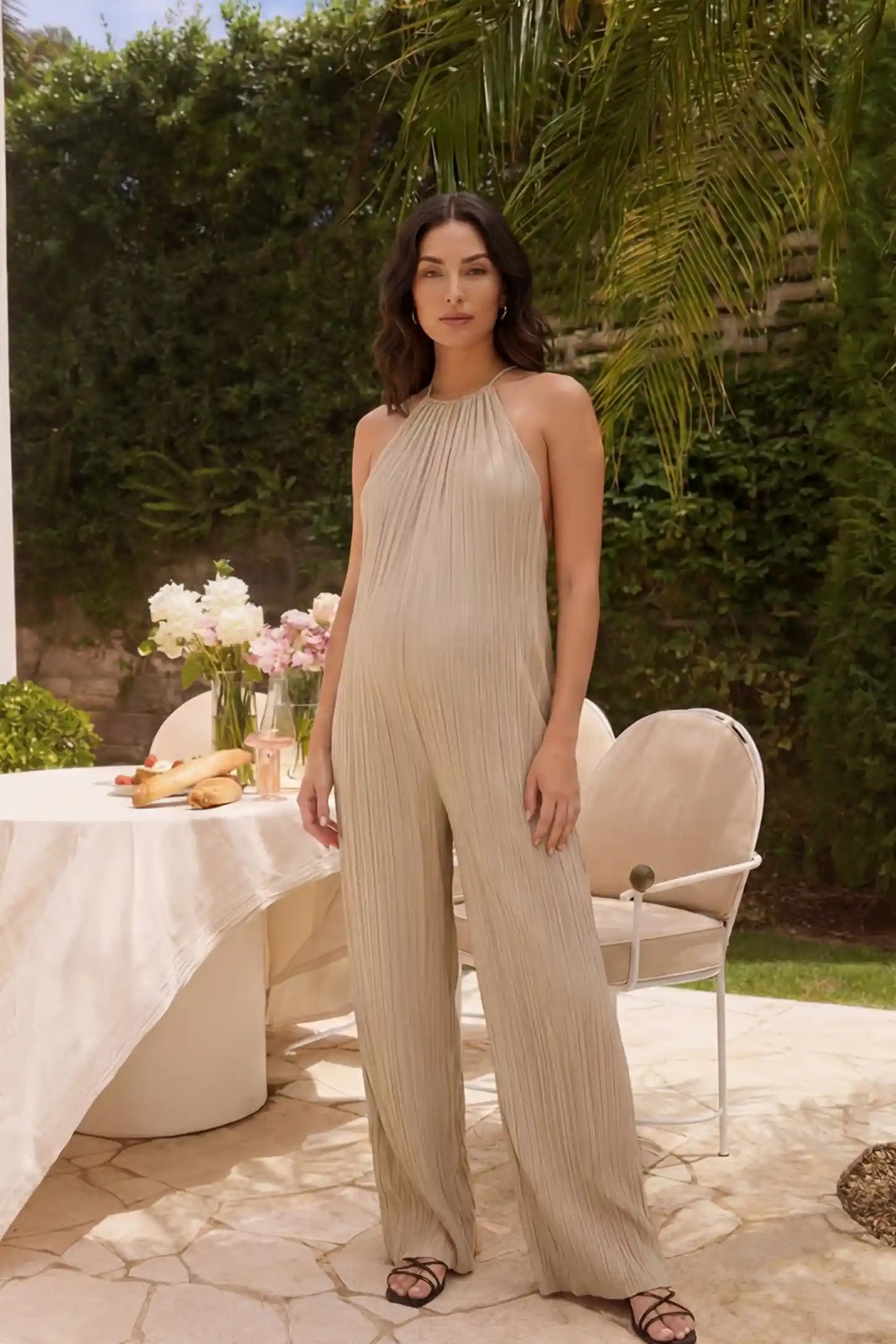 Halter Neck Wide Leg Pocketed Maternity Jumpsuit Halter Neck Wide Leg Pocketed Maternity Jumpsuit in Khaki featuring a gathered halter neck and ribbed fabric on a pregnant model, UGC-style view.