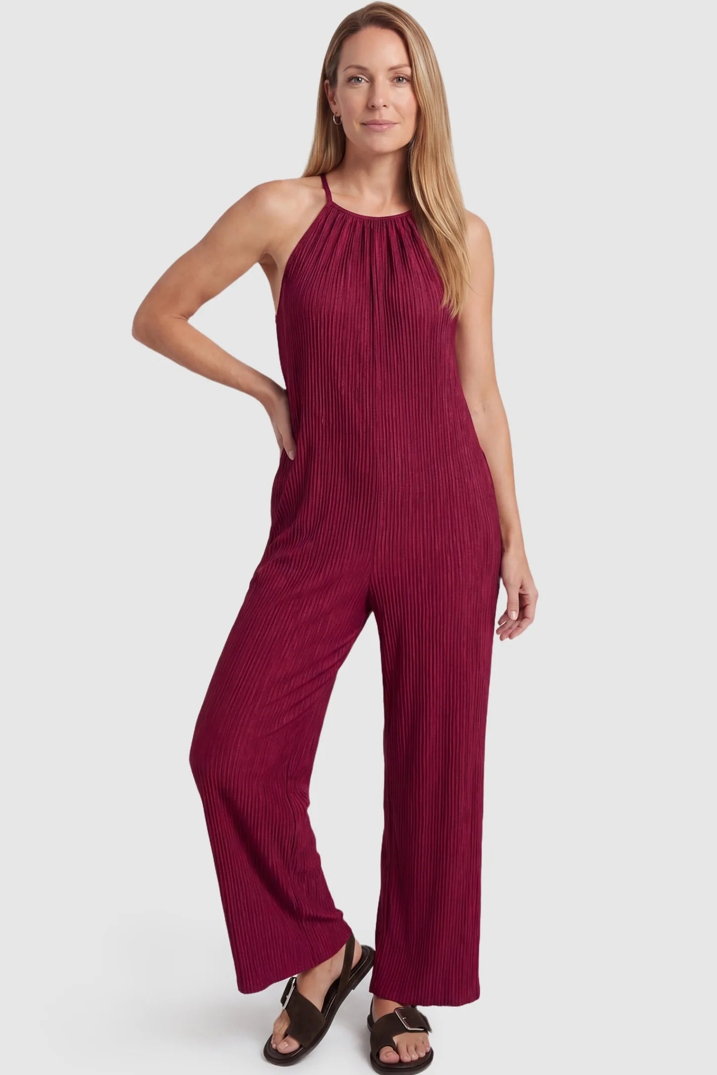 Halter Neck Wide Leg Pocketed Maternity Jumpsuit Halter Neck Wide Leg Pocketed Maternity Jumpsuit in Wine Red featuring a halter neck and soft ribbing on a postpartum model, front view.