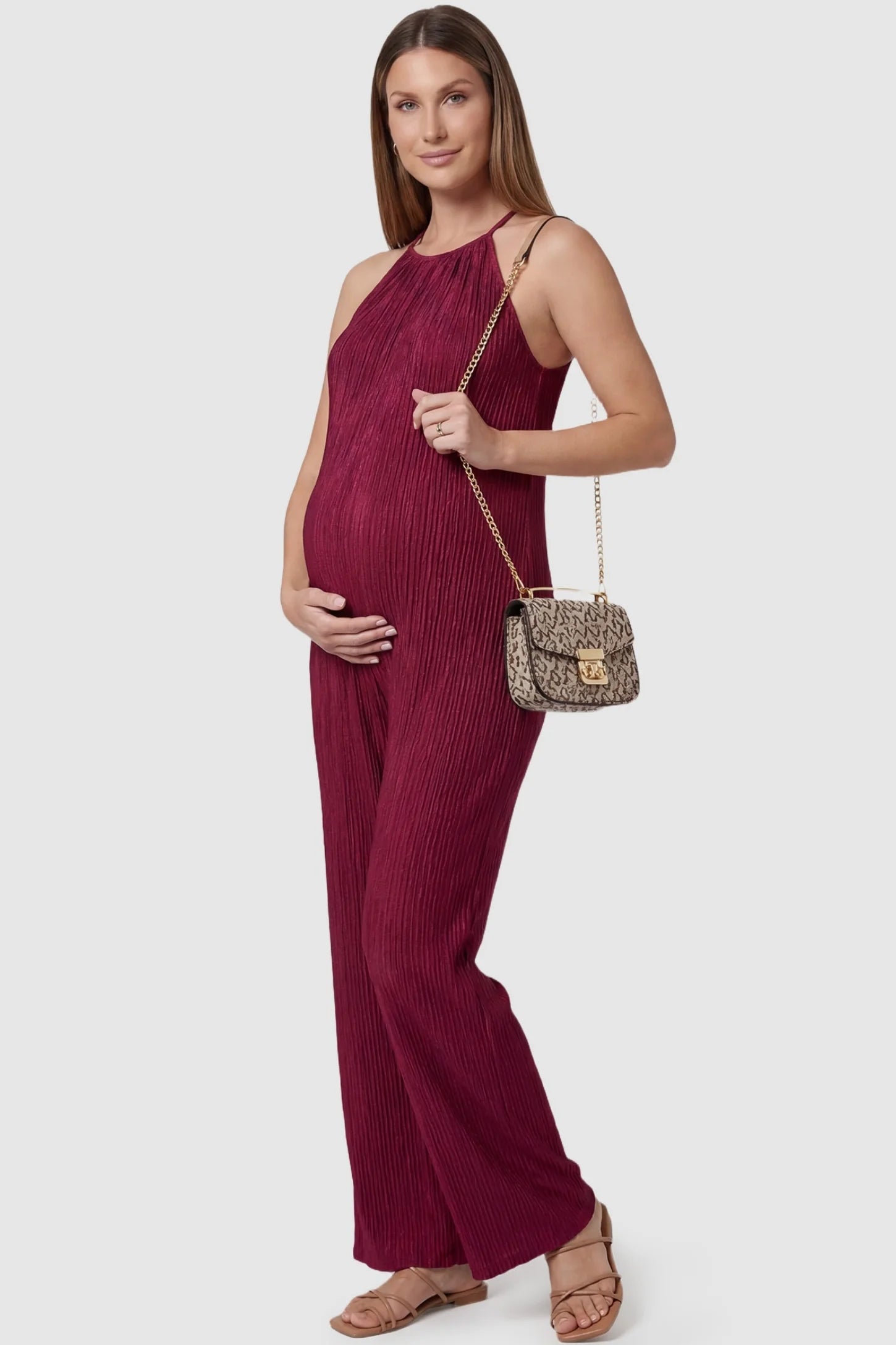 Halter Neck Wide Leg Pocketed Maternity Jumpsuit Halter Neck Wide Leg Pocketed Maternity Jumpsuit in Wine Red featuring a ribbed halter neck design on a pregnant model,styled lifestyle view.