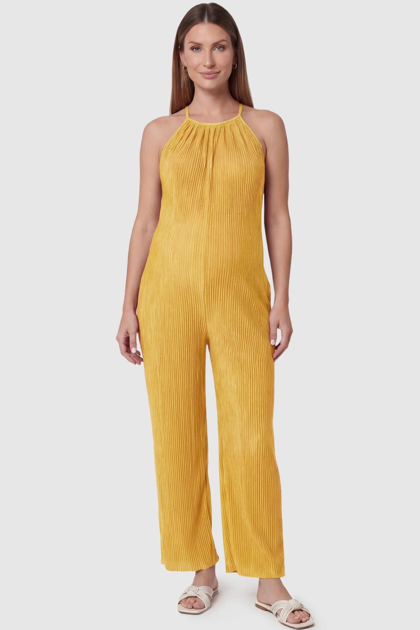 Halter Neck Wide Leg Pocketed Maternity Jumpsuit Halter Neck Wide Leg Pocketed Maternity Jumpsuit in Yellow featuring a gathered halter neck and ribbed texture on a pregnant model, front view.