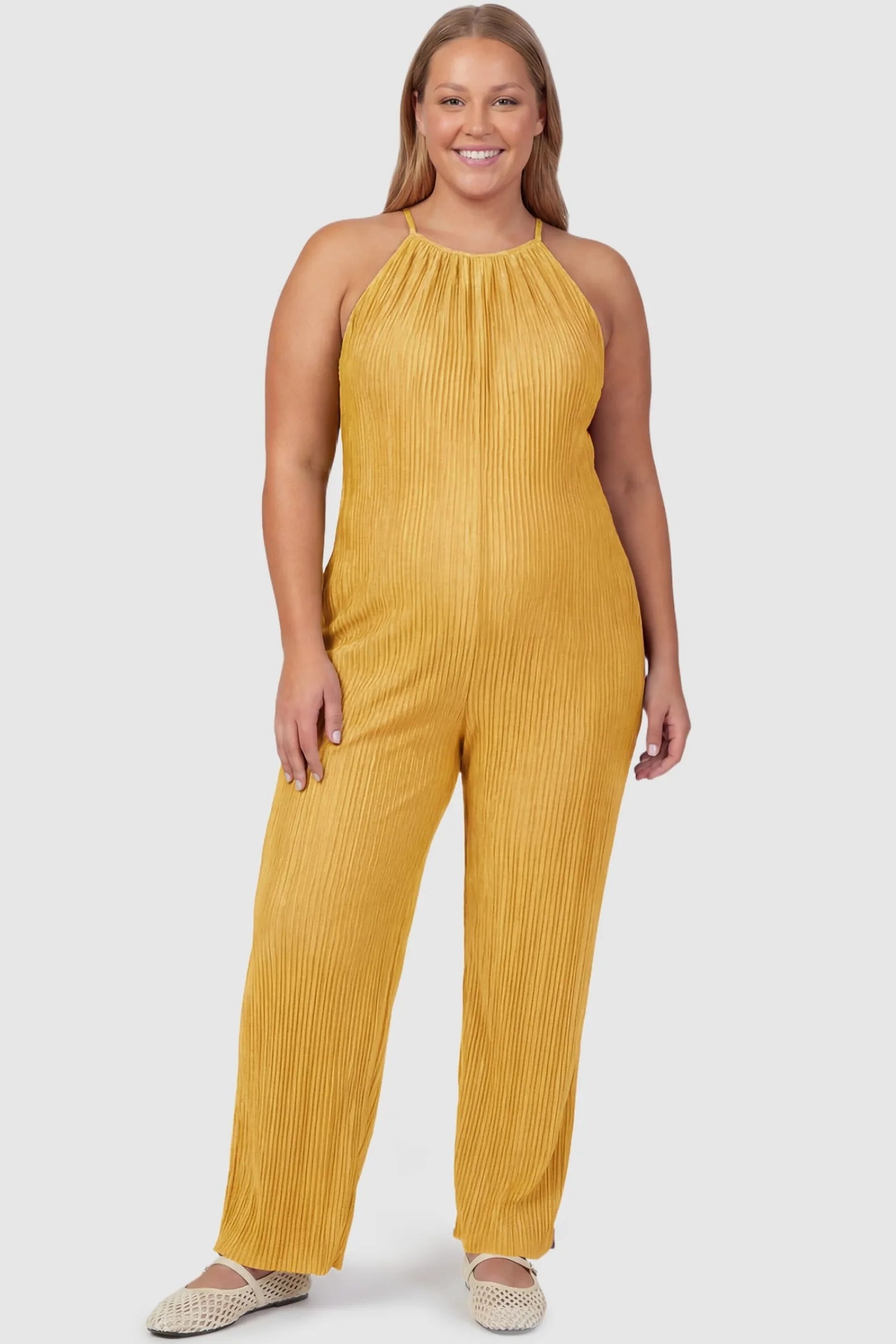 Halter Neck Wide Leg Pocketed Maternity Jumpsuit Halter Neck Wide Leg Pocketed Maternity Jumpsuit in Yellow featuring a gathered halter neck and ribbed texture on a plus-size pregnant model, front view.
