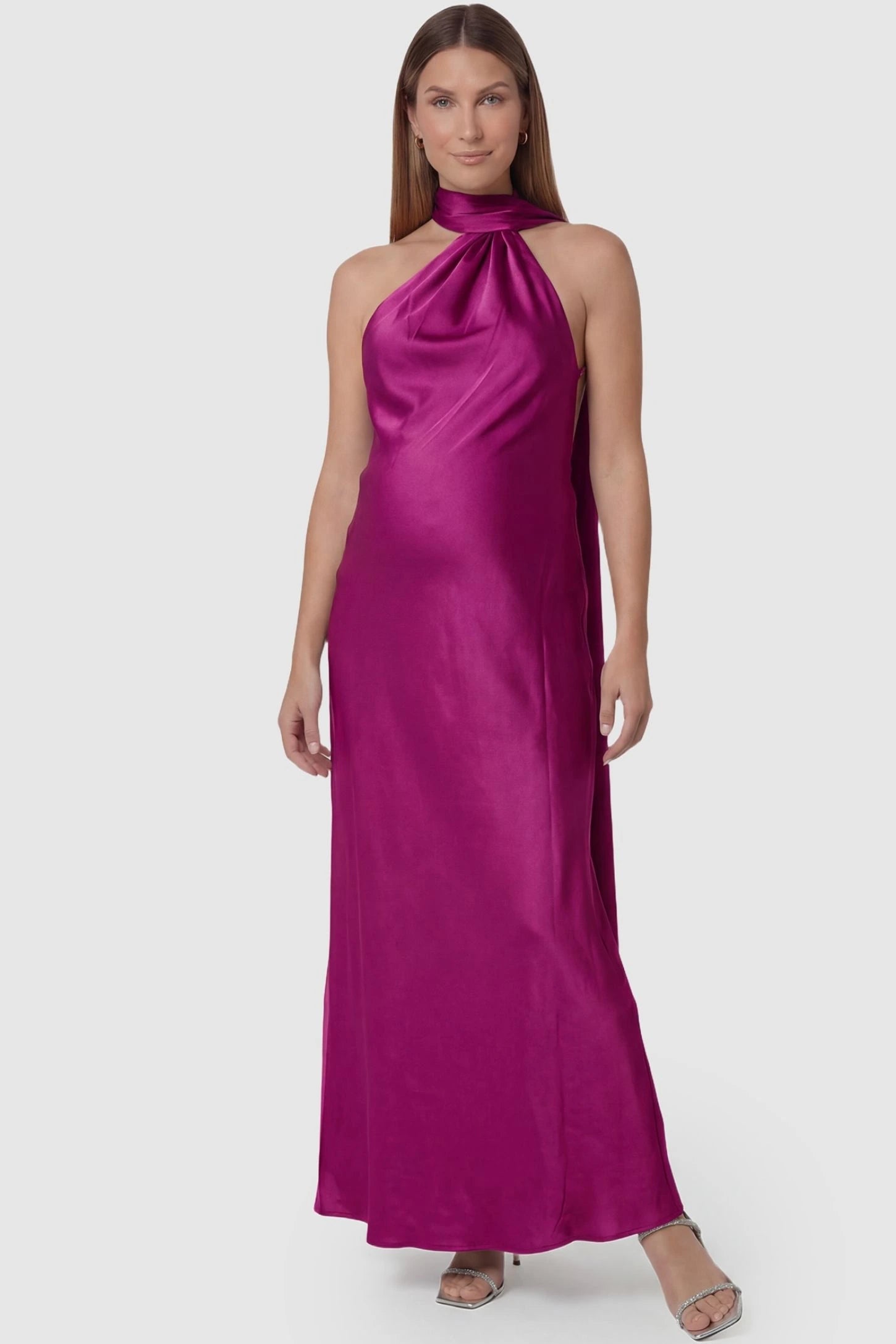 High-Shine Halter Sleeveless Maternity Maxi Dress High-Shine Halter Sleeveless Maternity Maxi Dress in Pink featuring a shimmering satin finish on a pregnant model, front view.