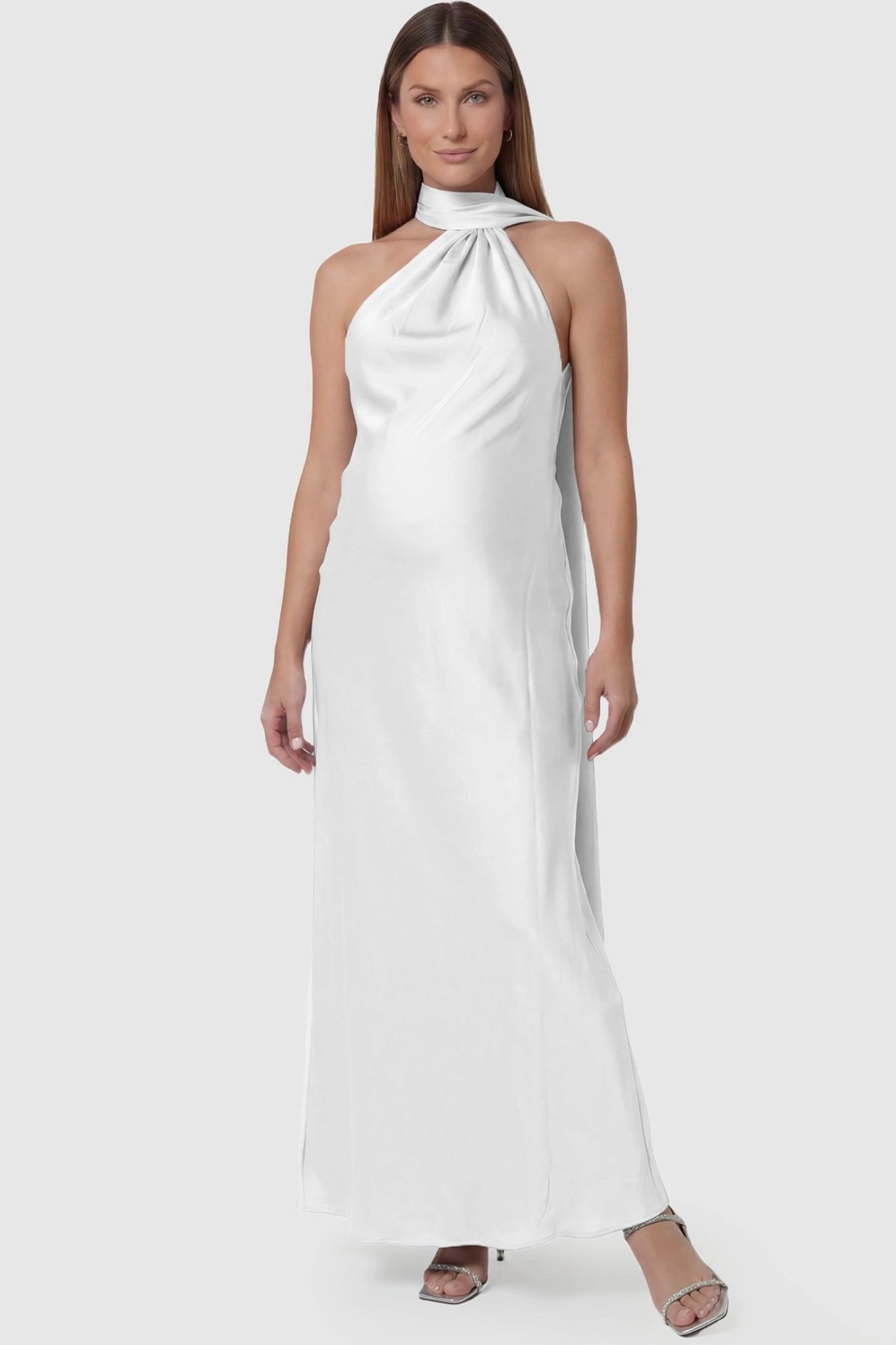 High-Shine Halter Sleeveless Maternity Maxi Dress High-Shine Halter Sleeveless Maternity Maxi Dress in White featuring a sophisticated halter neck on a pregnant model, front view.