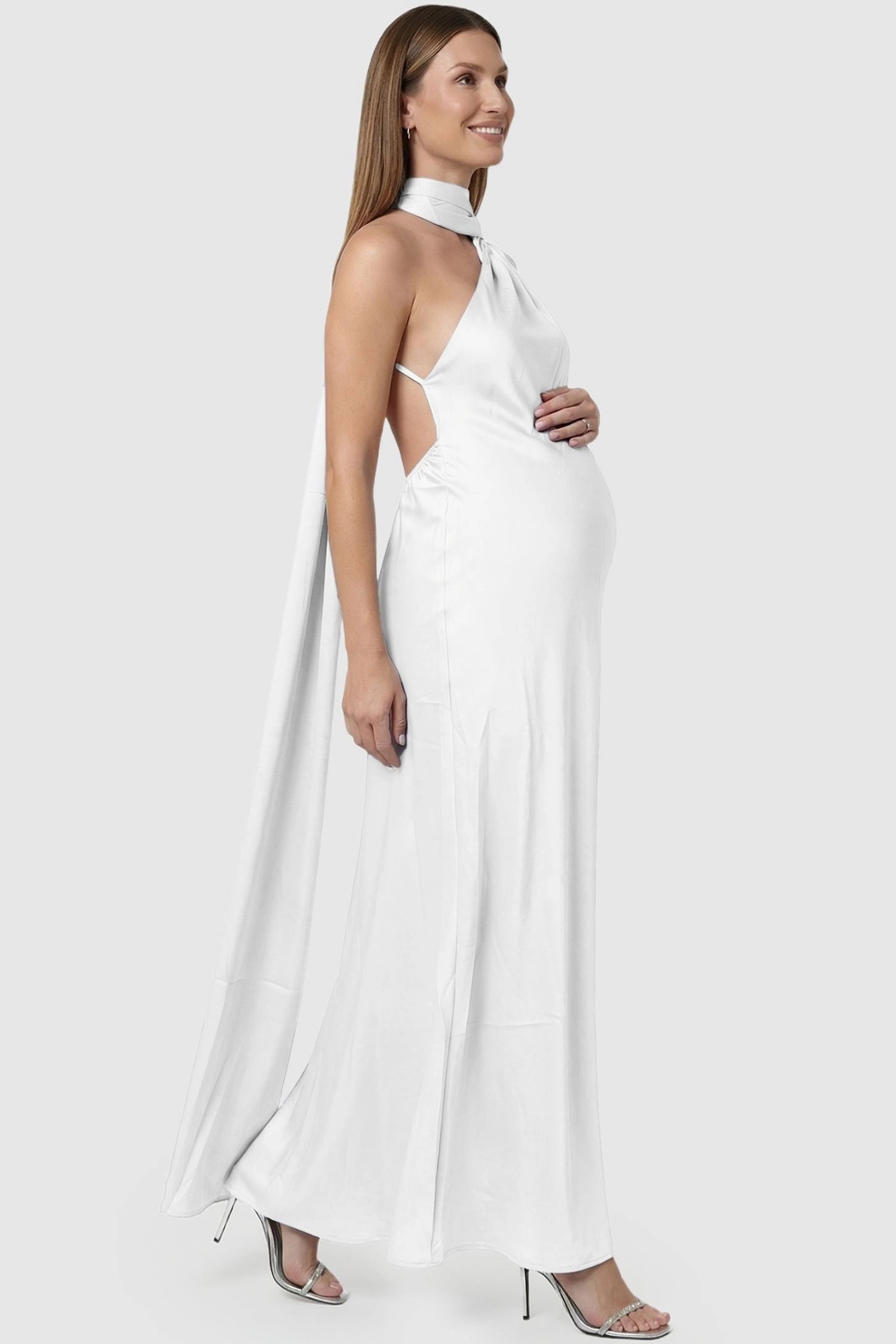 High-Shine Halter Sleeveless Maternity Maxi Dress High-Shine Halter Sleeveless Maternity Maxi Dress in White featuring a sleek, sleeveless design on a pregnant model, side view.