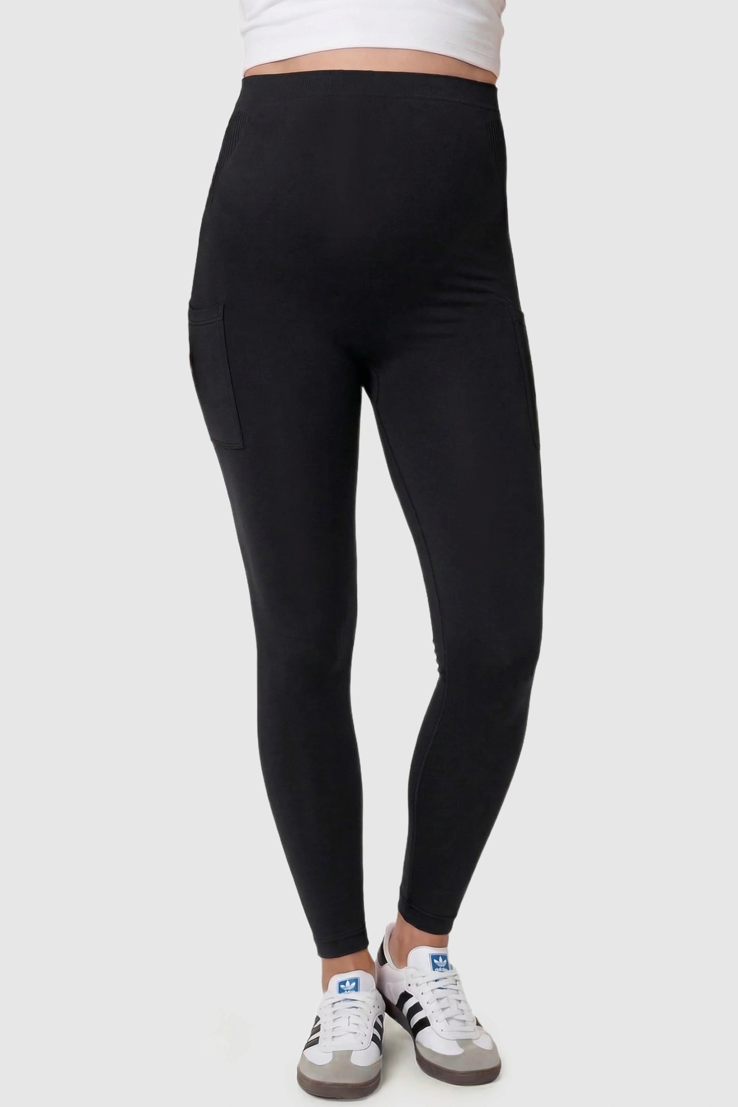 High-Waist Ankle-Length Pocketed Maternity Leggings in Black featuring a seamless waistband on a pregnant model, front view.
