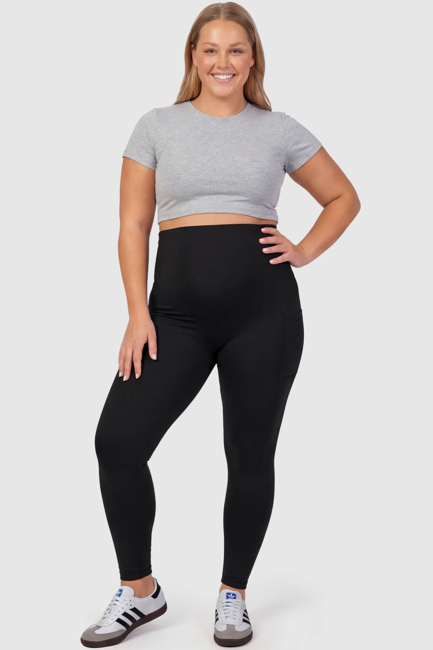 High Waist Ankle Length Pocketed Maternity Leggings High-Waist Ankle-Length Pocketed Maternity Leggings in Black featuring a seamless waistband on a plus size pregnant model, front view.
