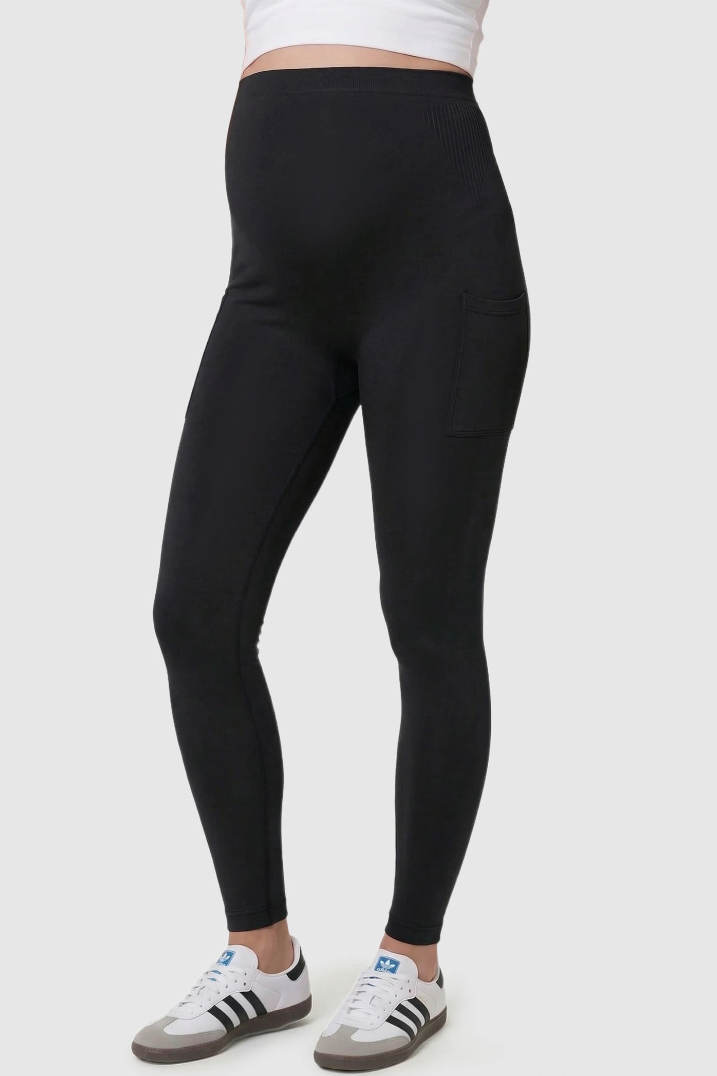 High Waist Ankle Length Pocketed Maternity Leggings High-Waist Ankle-Length Pocketed Maternity Leggings in Black featuring a seamless waistband on a pregnant model, side view.