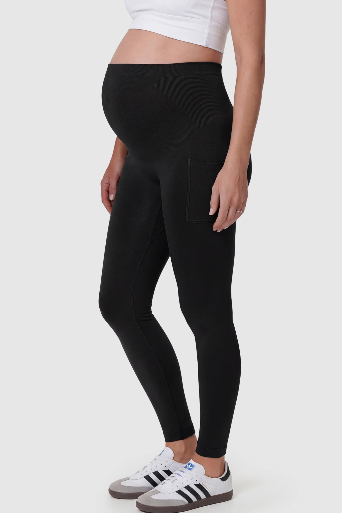 High Waist Ankle Length Pocketed Maternity Leggings High-Waist Ankle-Length Pocketed Maternity Leggings in Black featuring a seamless waistband on a pregnant model showing side.
