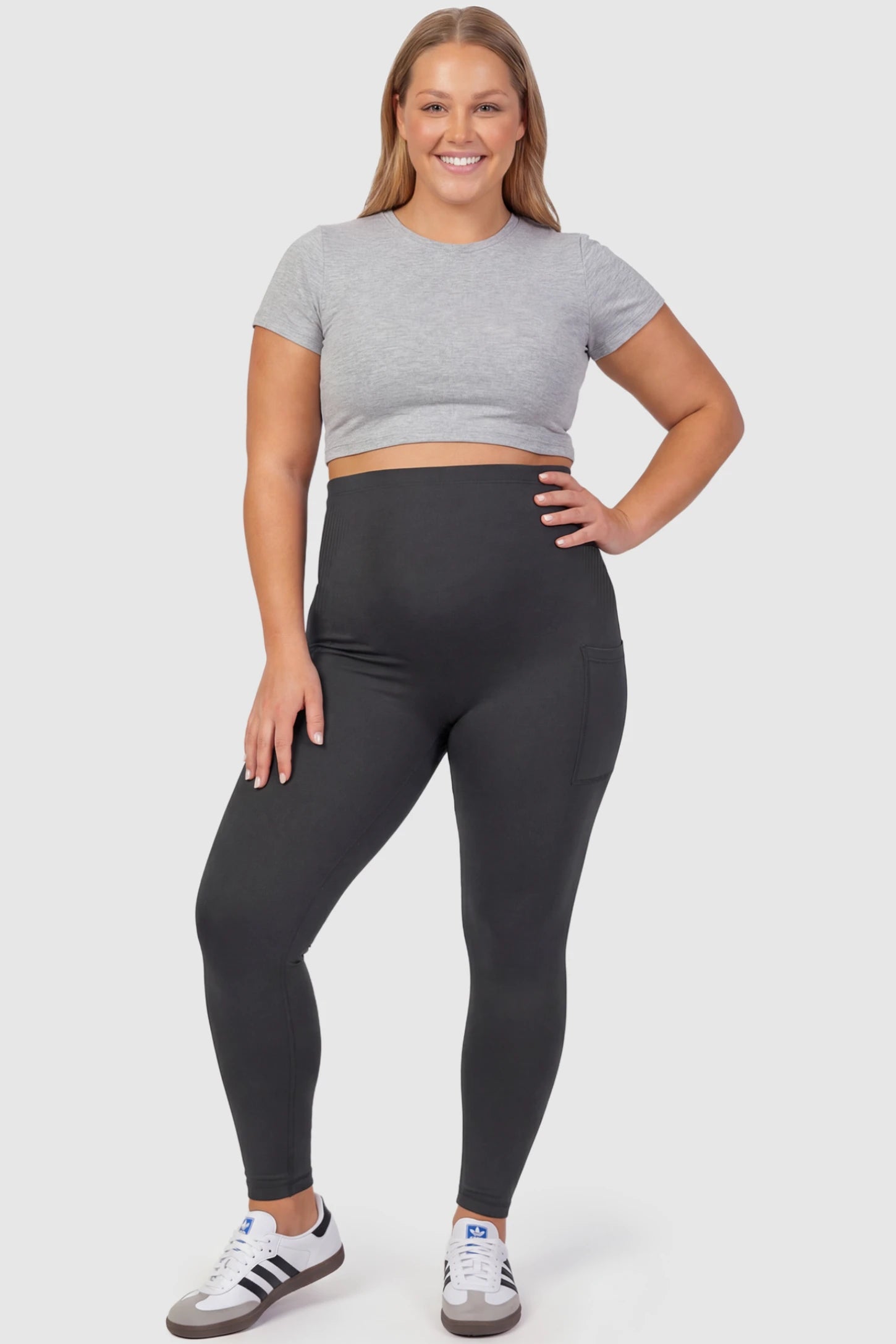 High Waist Ankle Length Pocketed Maternity Leggings High-Waist Ankle-Length Pocketed Maternity Leggings in Gray featuring a seamless waistband on a plus size pregnant model, front view.