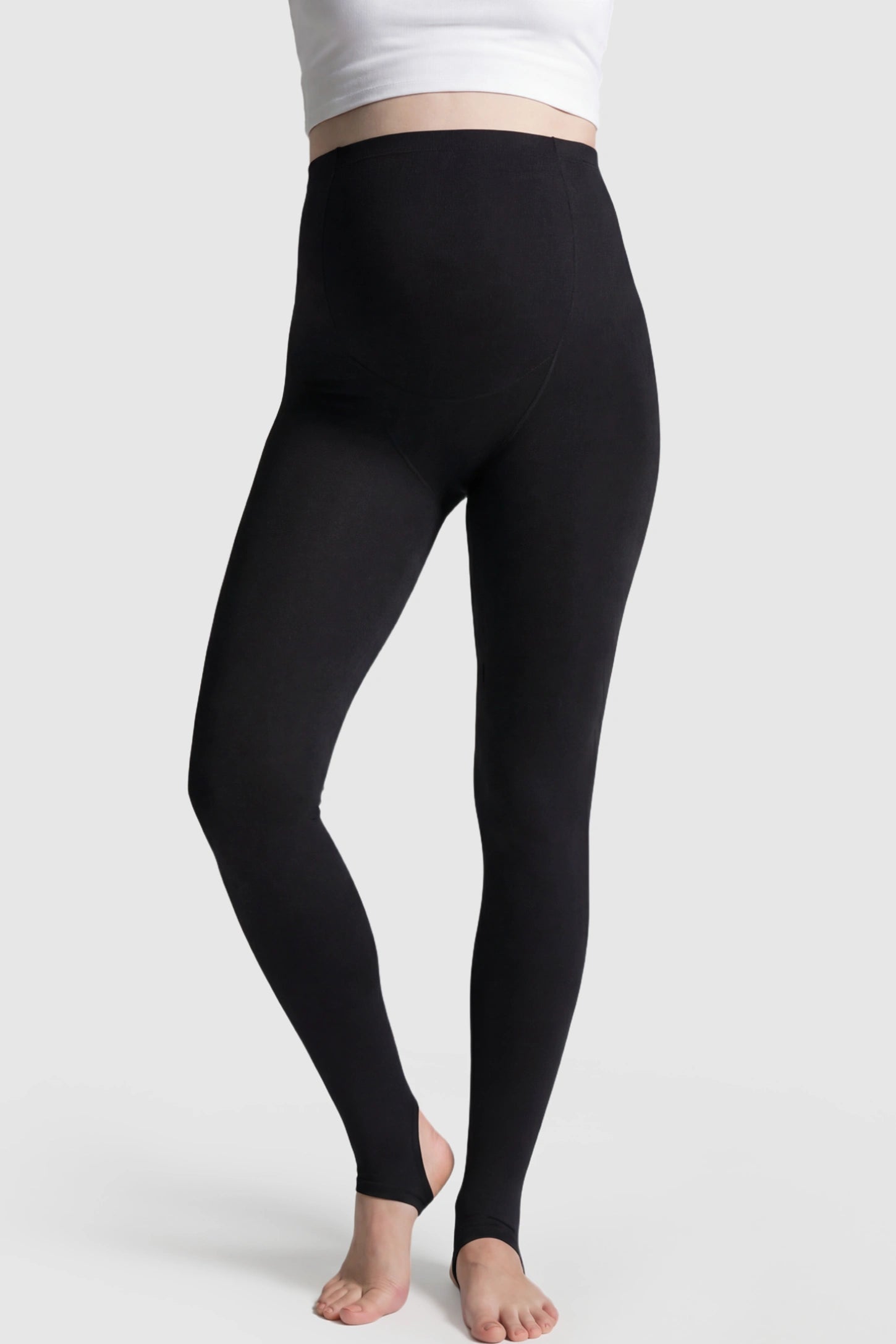 High Waist Fleece-Lined Stirrup Maternity Leggings High Waist Fleece-Lined Stirrup Maternity Leggings in Black featuring a supportive over-the-belly panel on a pregnant model showing front.