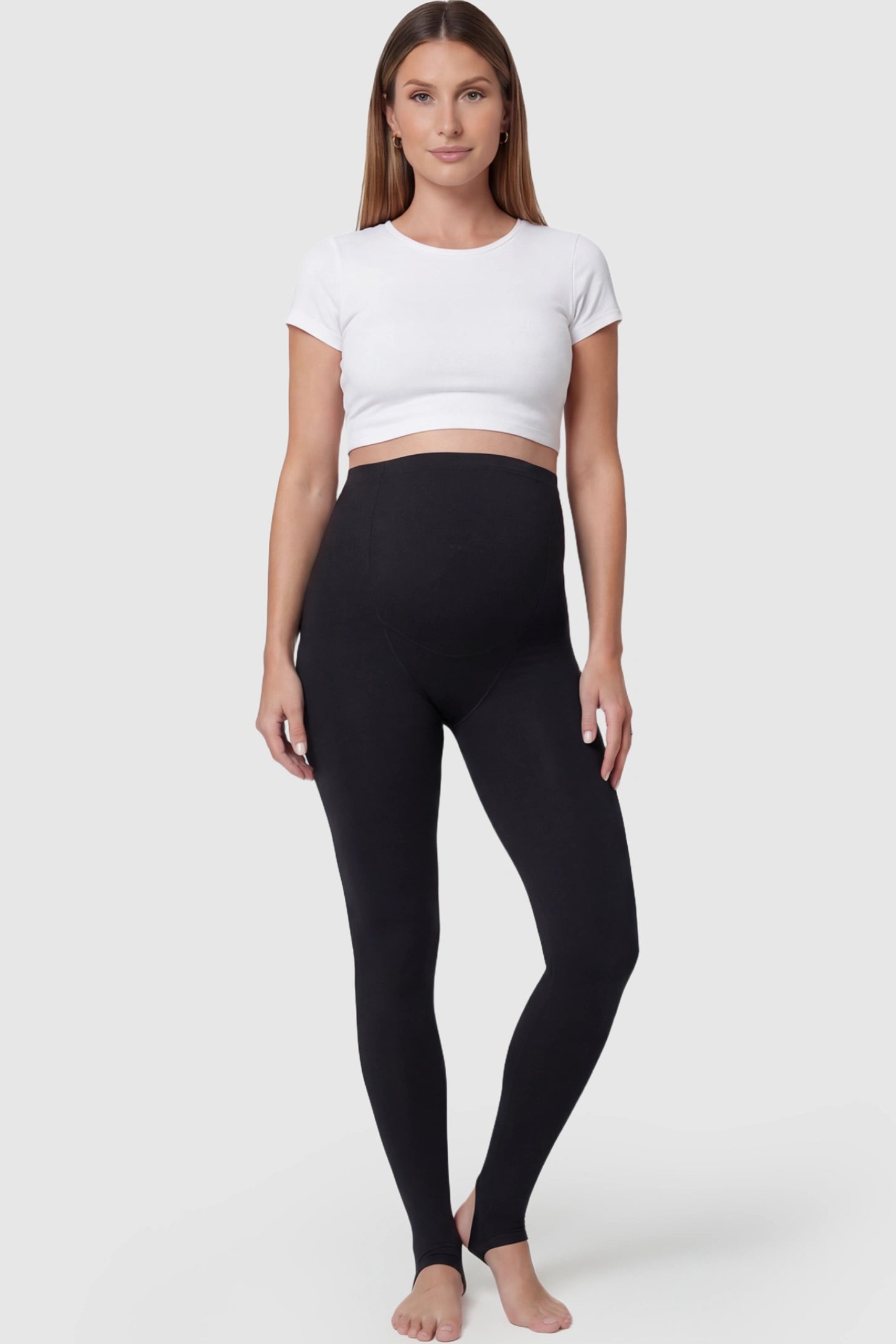 High Waist Fleece-Lined Stirrup Maternity Leggings High Waist Fleece-Lined Stirrup Maternity Leggings in Black featuring a supportive over-the-belly panel on a pregnant model posing front.