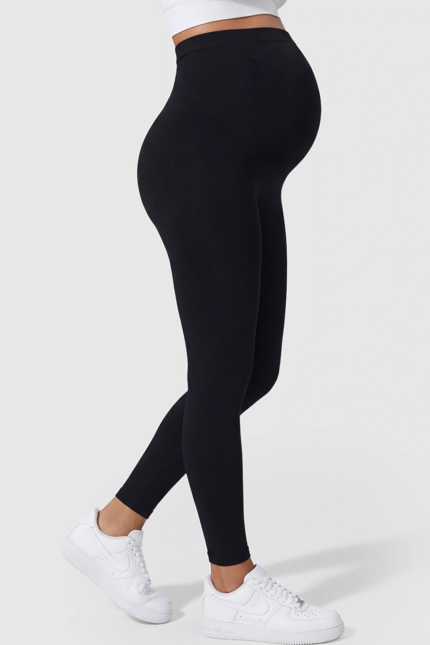 High Waist Full Length Maternity Leggings High Waist Seamless Full-Length Maternity Leggings in Black featuring a supportive waistband on a pregnant model showing side.