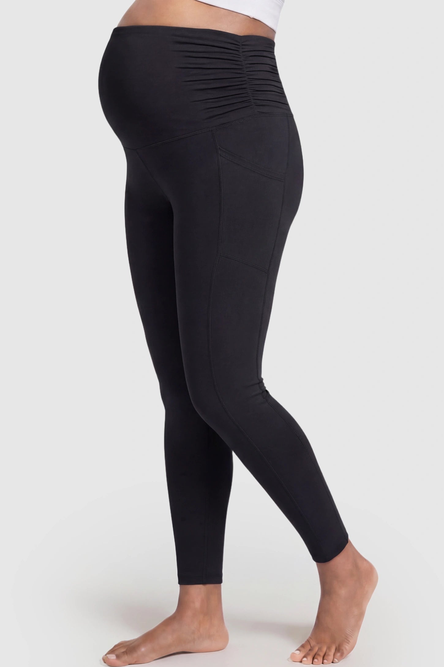 High Waist Full Panel Pocketed Maternity Leggings High Waist Full Panel Maternity Leggings in Black featuring side pockets on a pregnant model showing side.