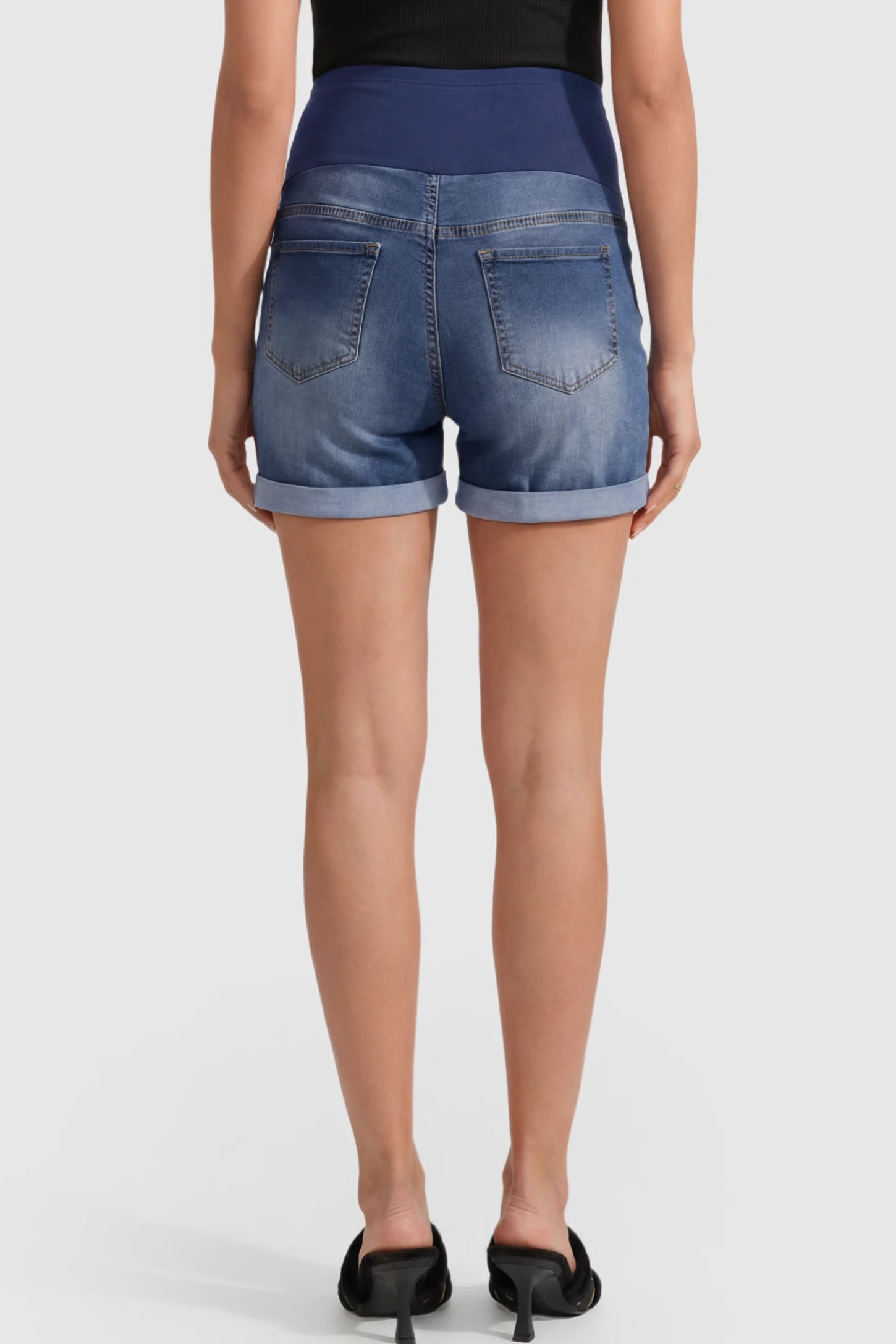 High Waist Rolled Hem Maternity Denim Shorts High Waist Rolled-Hem Maternity Denim Shorts in Dark Blue featuring a navy over-the-belly panel on a pregnant model showing back.