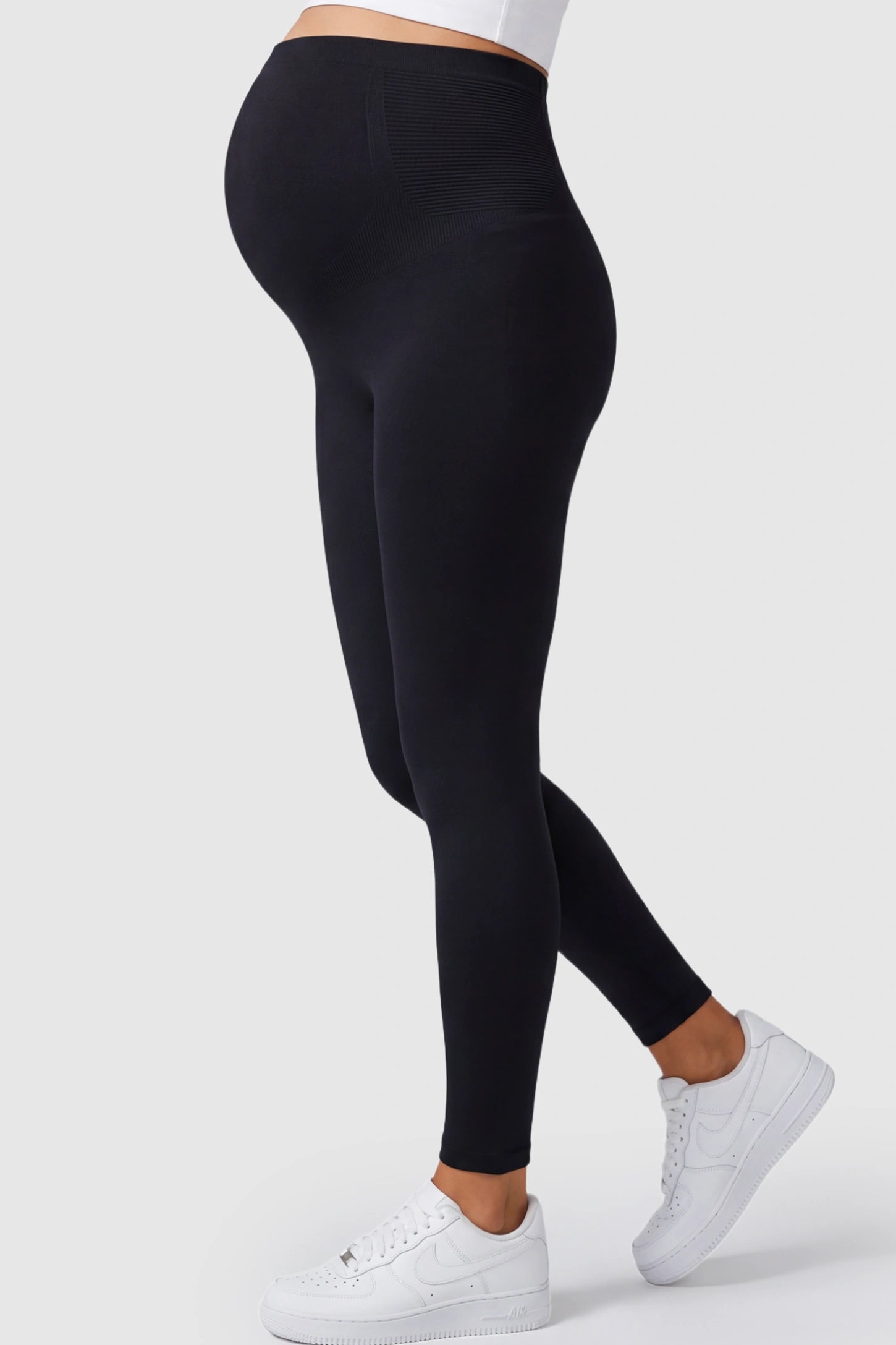 High Waisted Full Length Maternity Leggings High Waisted Full Length Maternity Leggings in Black featuring a seamless over-the-bump band on a pregnant model showing side.
