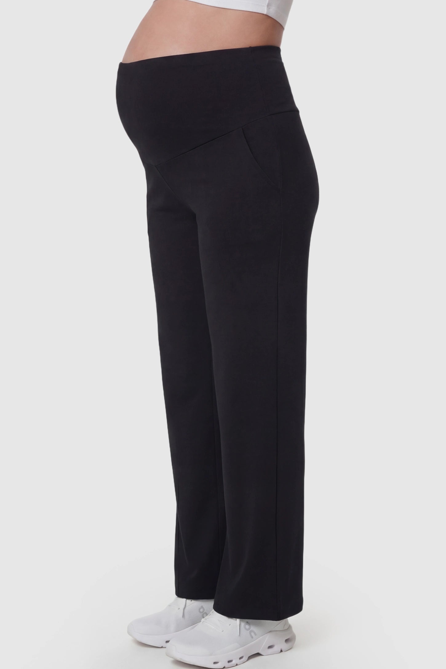 High Waisted Full Panel Wide Leg Maternity Pants High Waisted Full Panel Wide Leg Maternity Pants in Black featuring a stretch waistband on a pregnant model showing side.