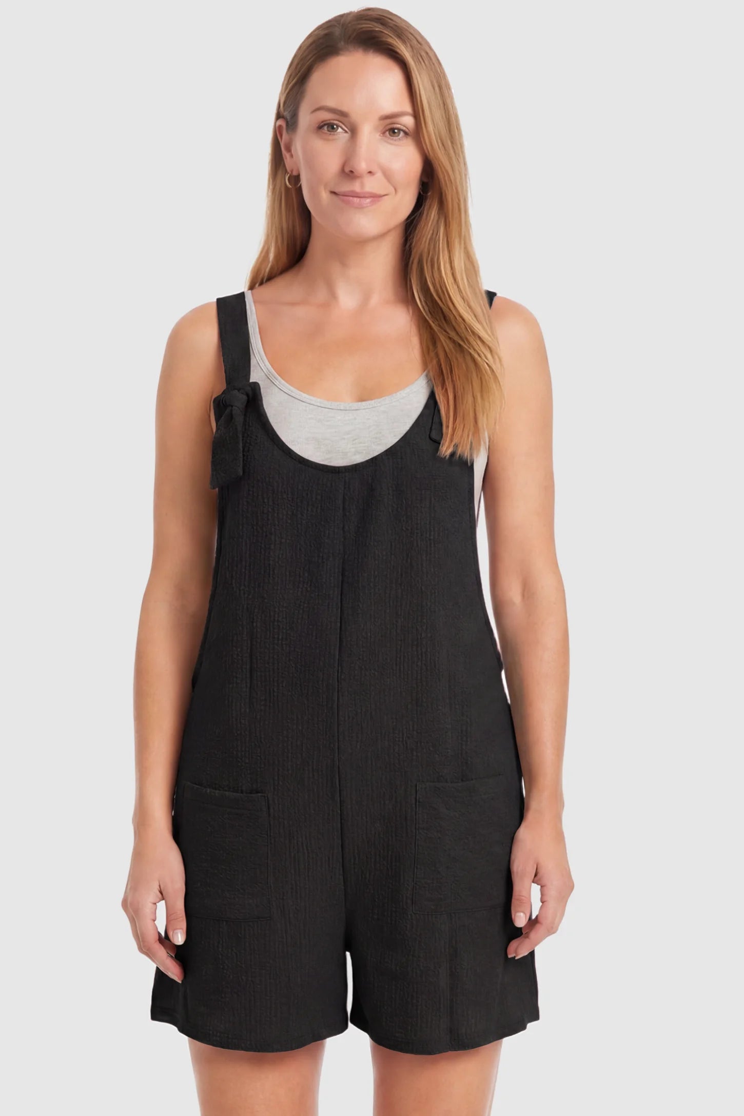 Knot Strap Front Pocket Maternity Romper Knot Strap Front Pocket Maternity Romper in Black featuring deep front pockets and a scoop neck on a postpartum model, front view.