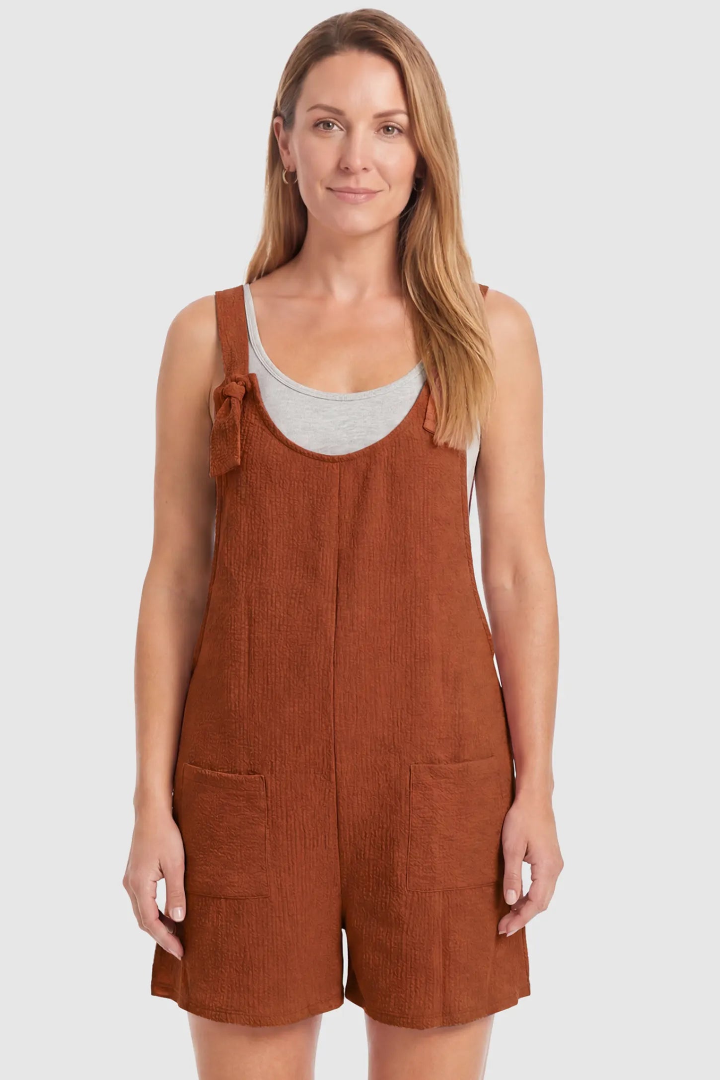 Knot Strap Front Pocket Maternity Romper Knot Strap Front Pocket Maternity Romper in Dark Brown featuring deep front pockets and a scoop neck on a postpartum model, front view.