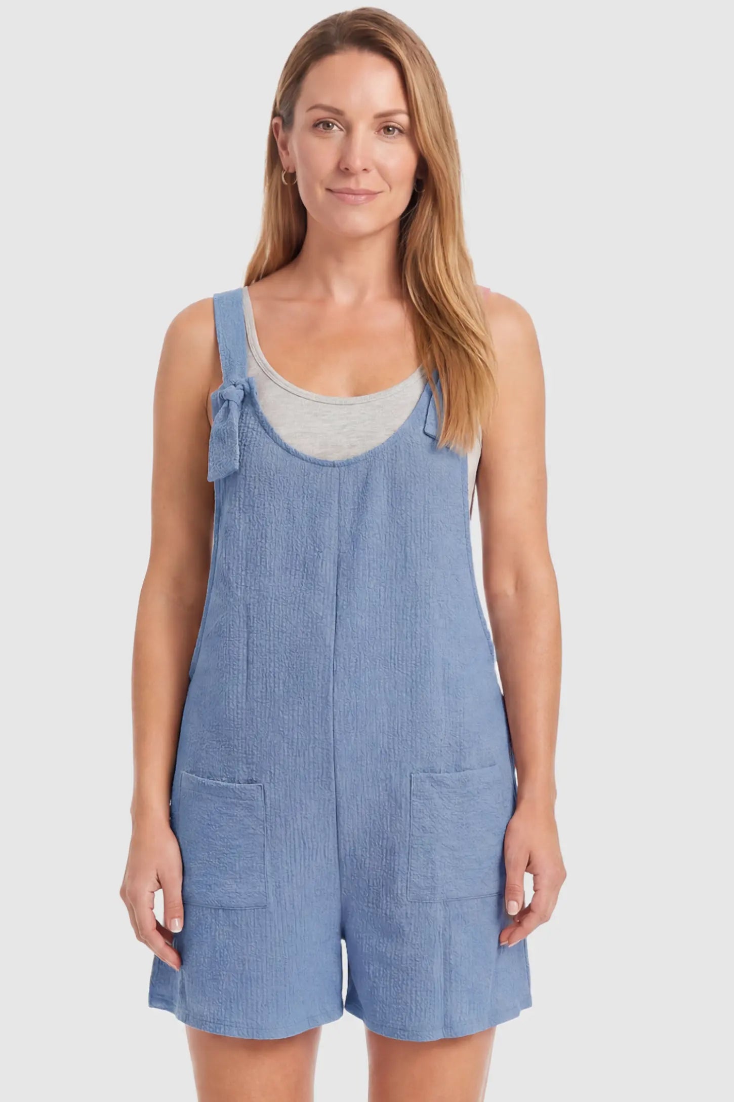 Knot Strap Front Pocket Maternity Romper Knot Strap Front Pocket Maternity Romper in Light Blue featuring deep front pockets and a scoop neck on a postpartum model, front view.