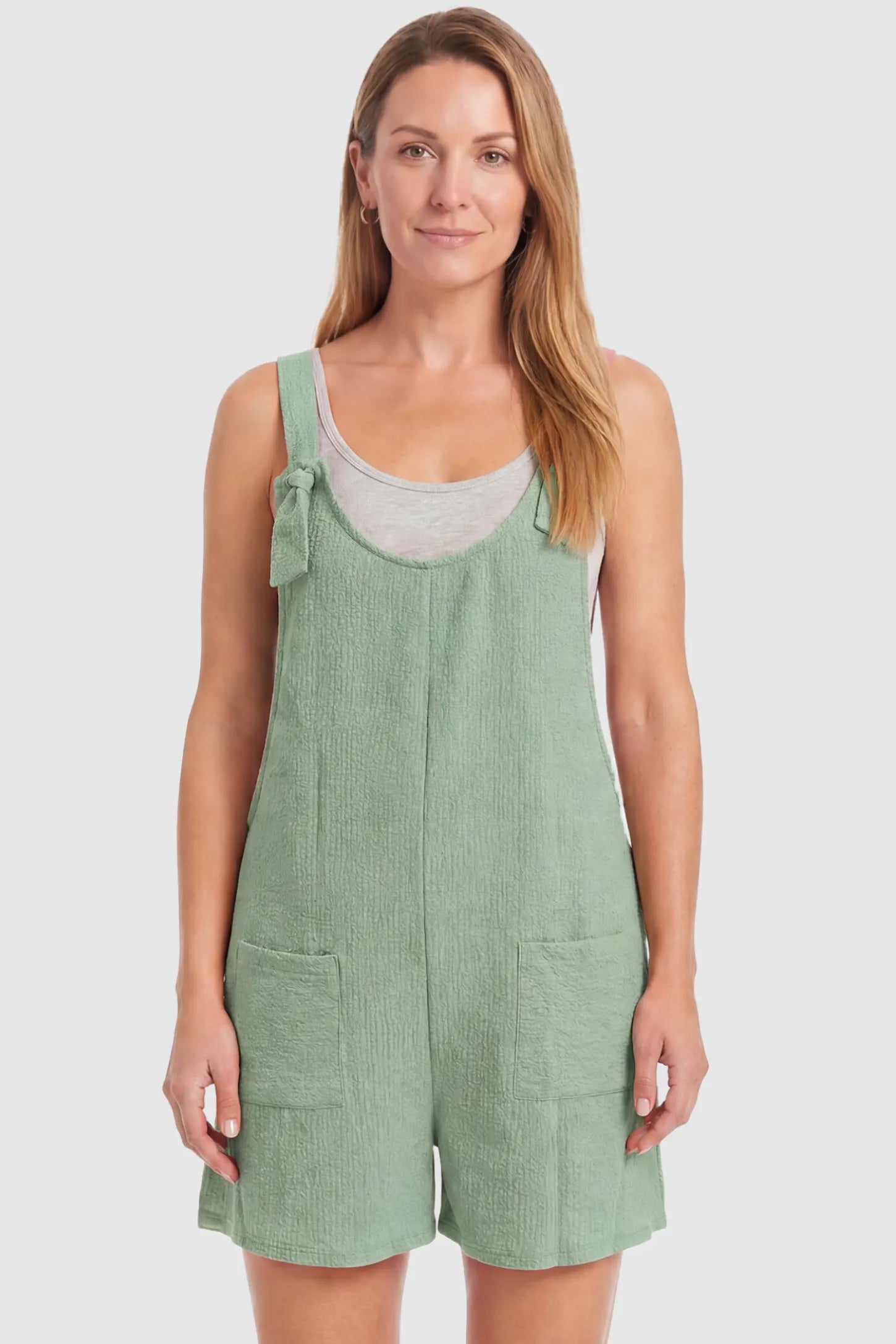 Knot Strap Front Pocket Maternity Romper Knot Strap Front Pocket Maternity Romper in Light Green featuring deep front pockets and a scoop neck on a postpartum model, front view.