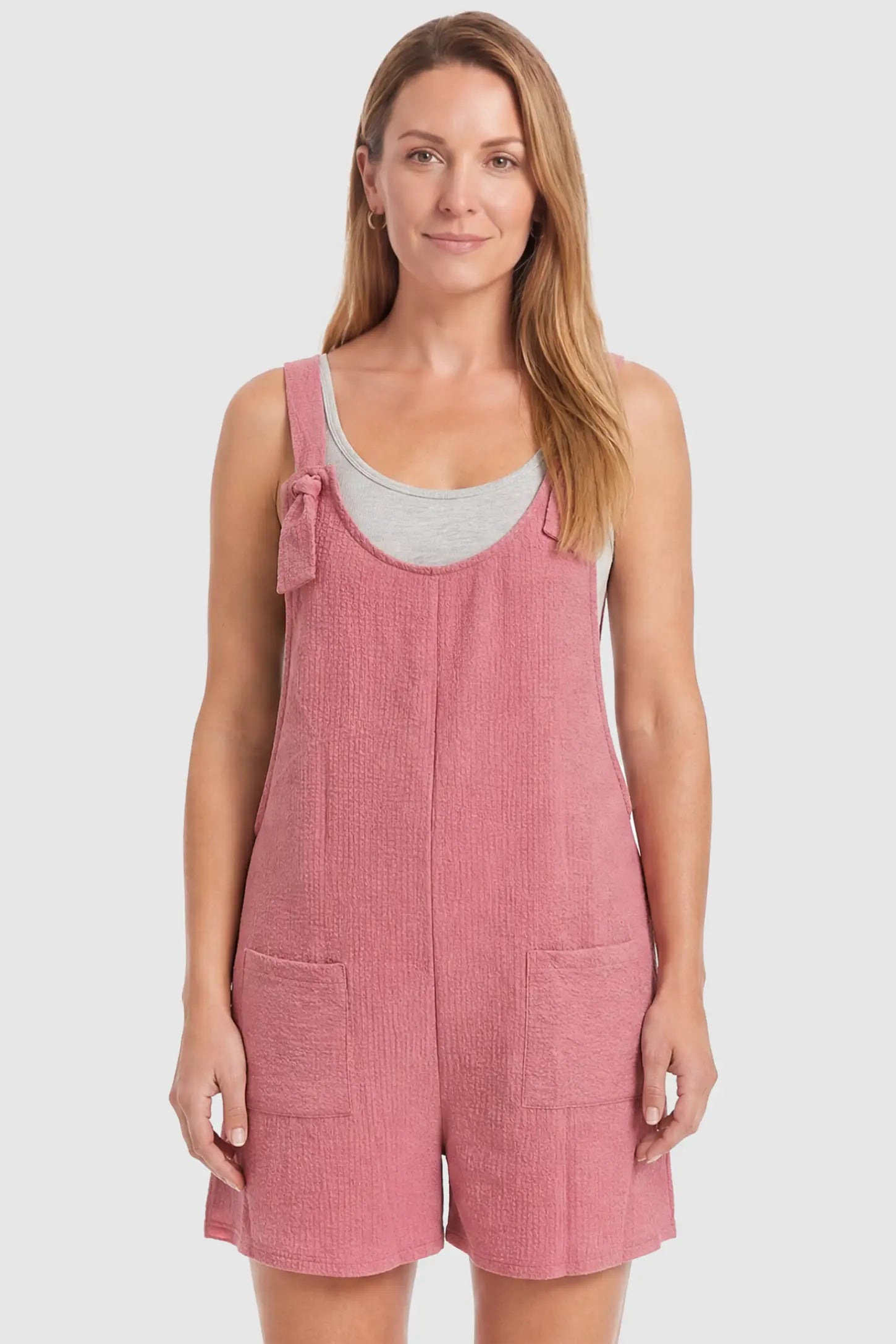 Knot Strap Front Pocket Maternity Romper Knot Strap Front Pocket Maternity Romper in Pink featuring deep front pockets and a scoop neck on a postpartum model, front view.