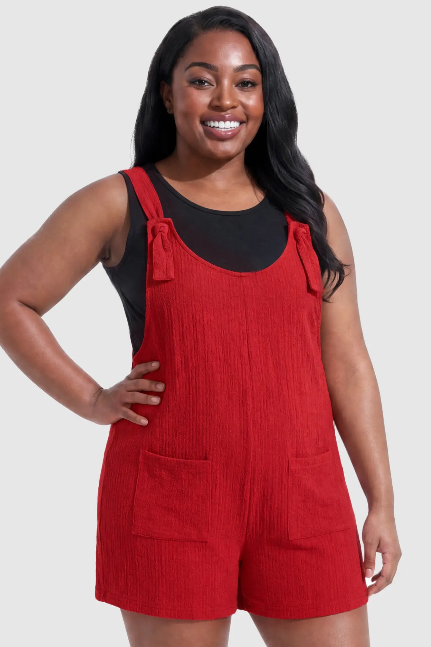 Knot Strap Front Pocket Maternity Romper Knot Strap Front Pocket Maternity Romper in Red featuring deep front pockets and a scoop neck on a plus size pregnant model, front view.