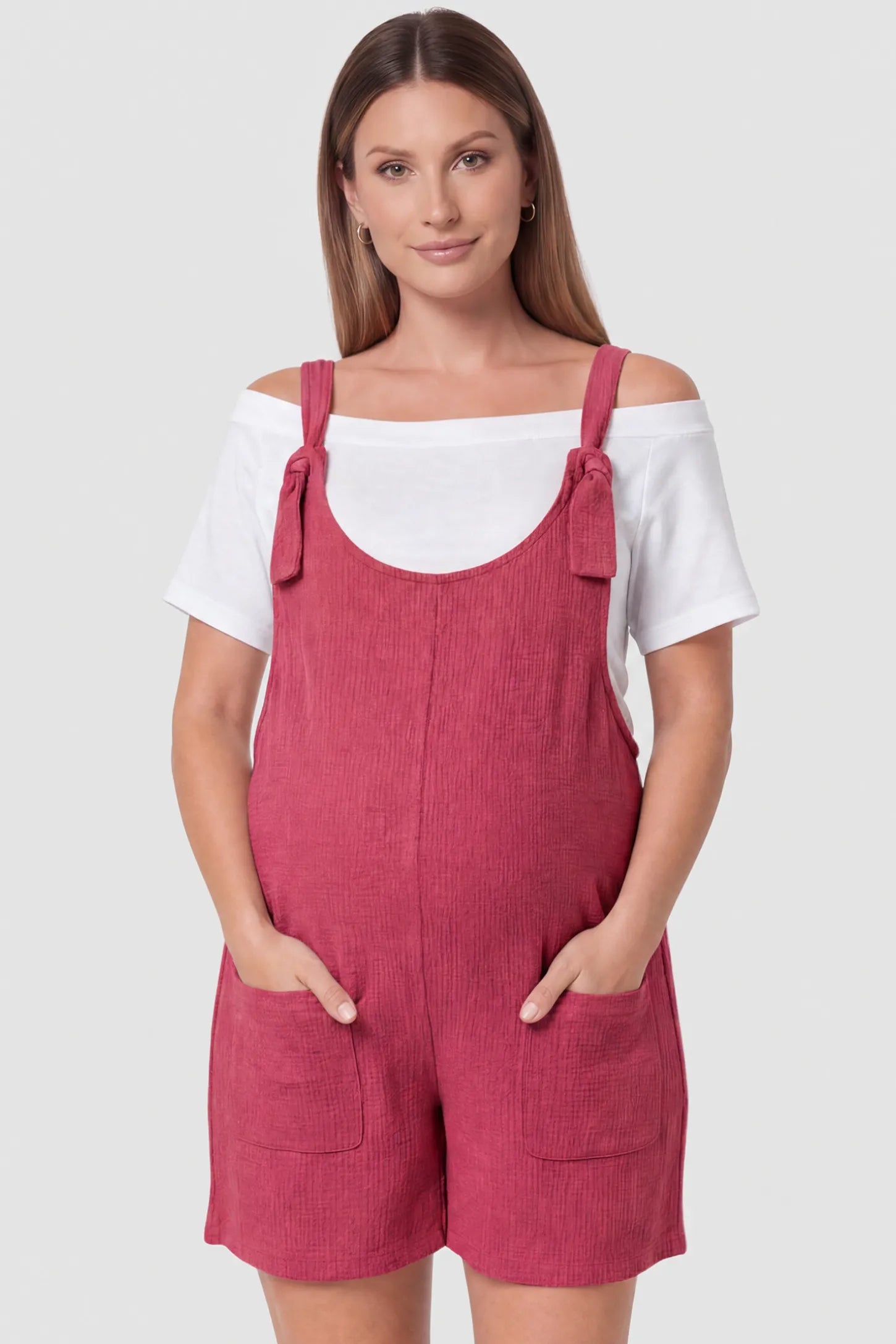 Knot Strap Front Pocket Maternity Romper Knot Strap Front Pocket Maternity Romper in Rose Red featuring deep front pockets and a scoop neck on a pregnant model, front view.