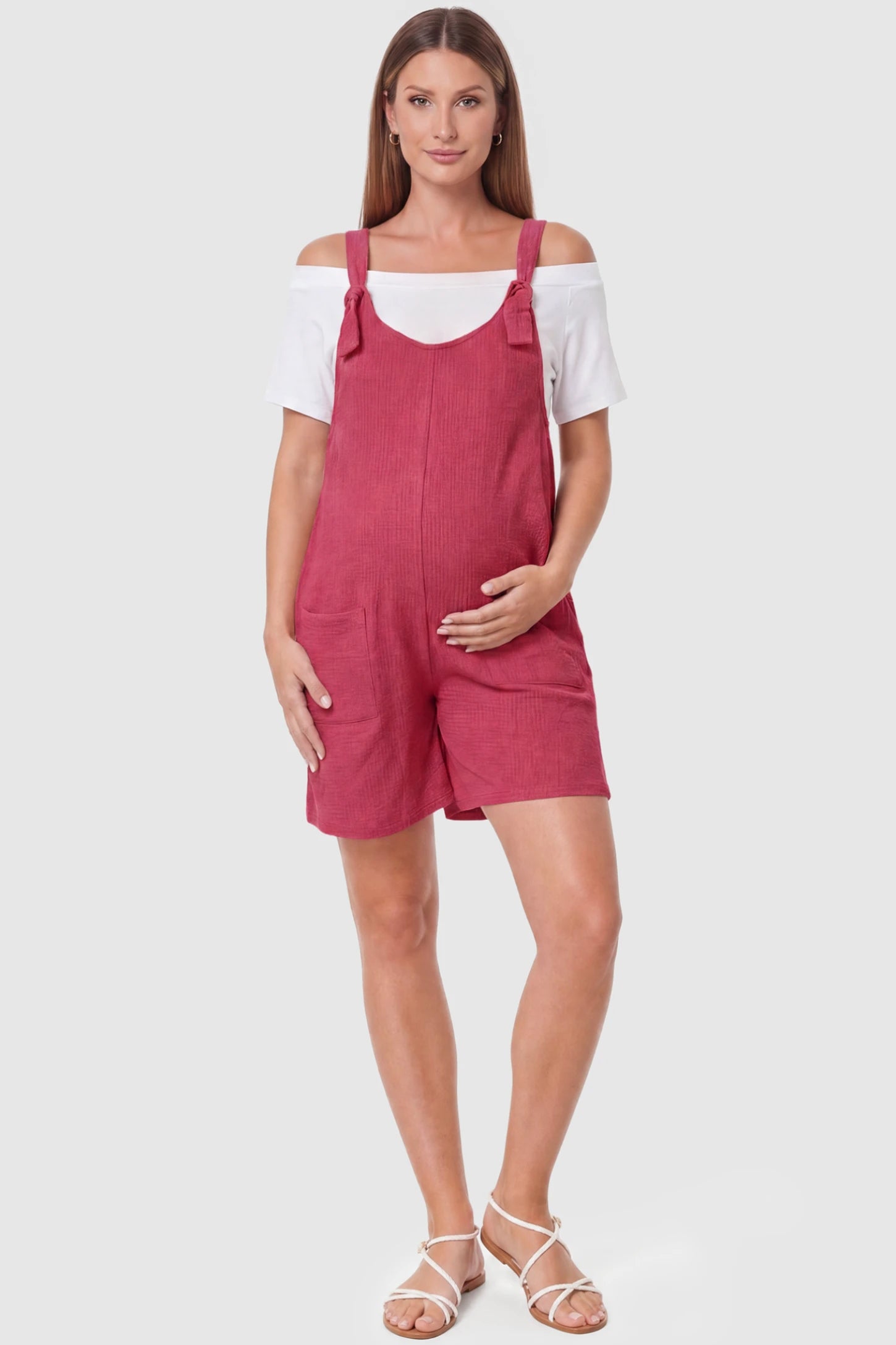 Knot Strap Front Pocket Maternity Romper Knot Strap Front Pocket Maternity Romper in Rose Red featuring deep front pockets and a scoop neck on a pregnant model, full body view.