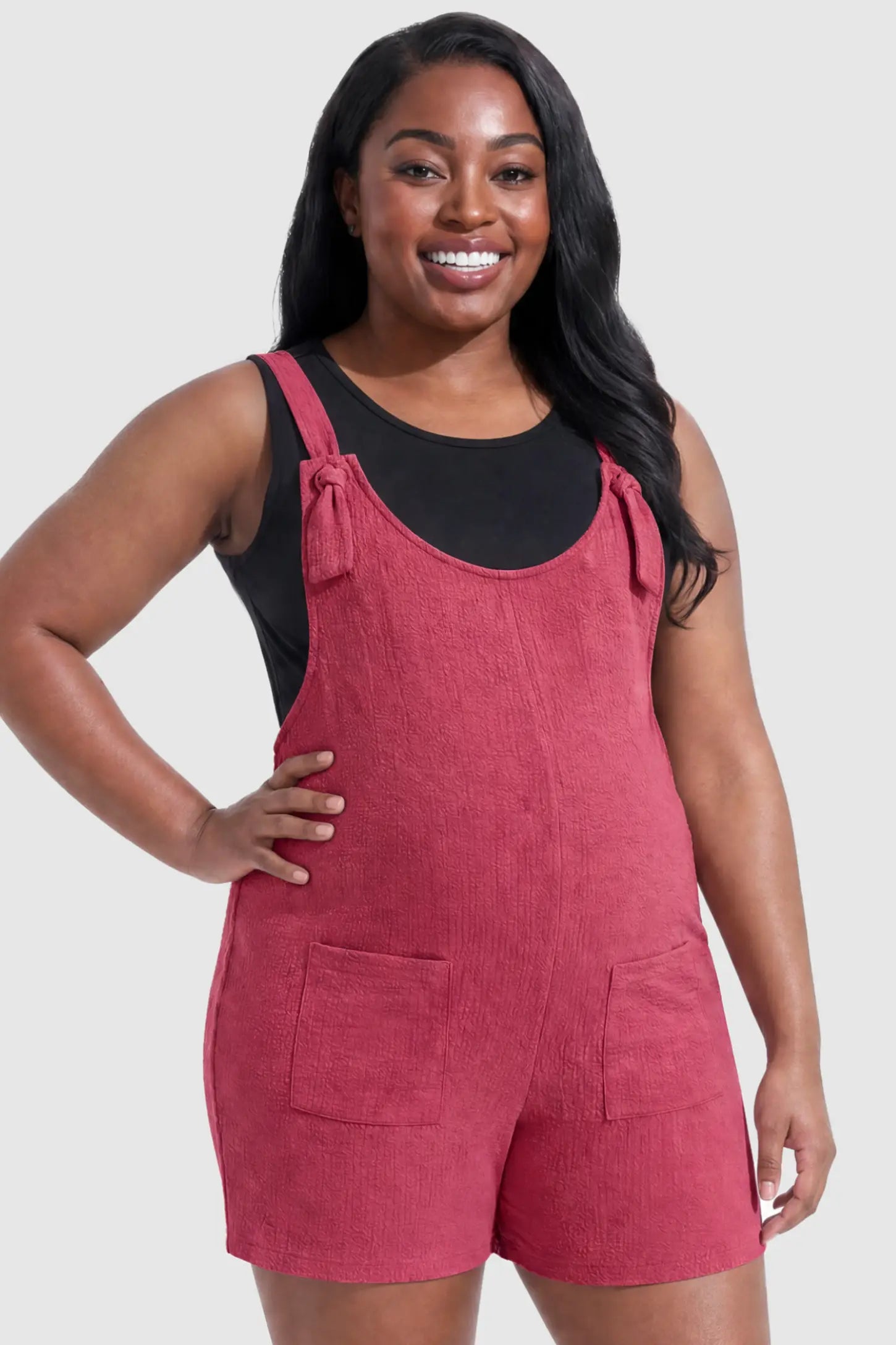 Knot Strap Front Pocket Maternity Romper Knot Strap Front Pocket Maternity Romper in Rose Red featuring deep front pockets and a scoop neck on a plus size pregnant model, front view.